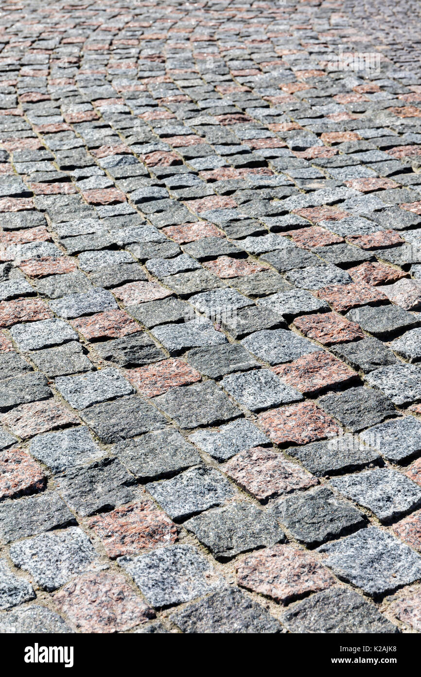 Grauer Granit Kopfsteinpflaster Hintergrund Fragment mit unebener Oberfläche Stockfoto