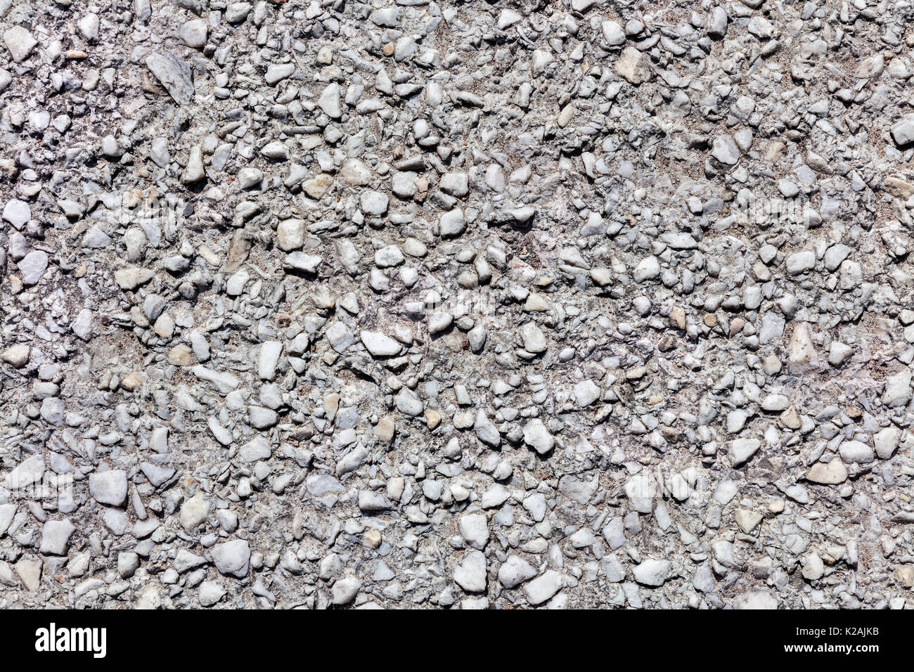 Alten verwitterten grauen Asphalt Oberflächenstruktur mit Schotter oder Kies Stockfoto