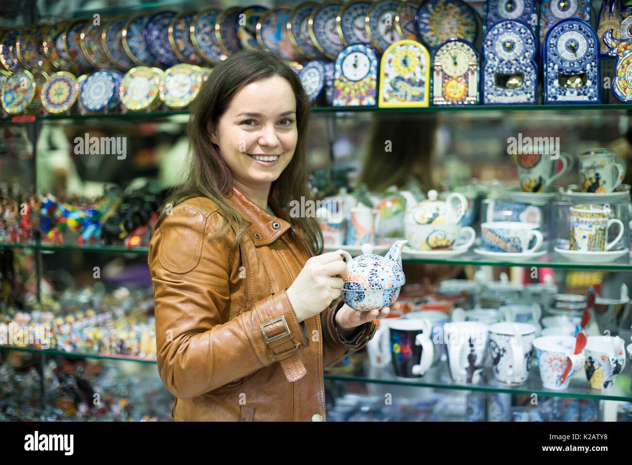 Lächelnd langhaarige Junge weibliche Kunden kaufen für Speicher im Souvenirshop Stockfoto