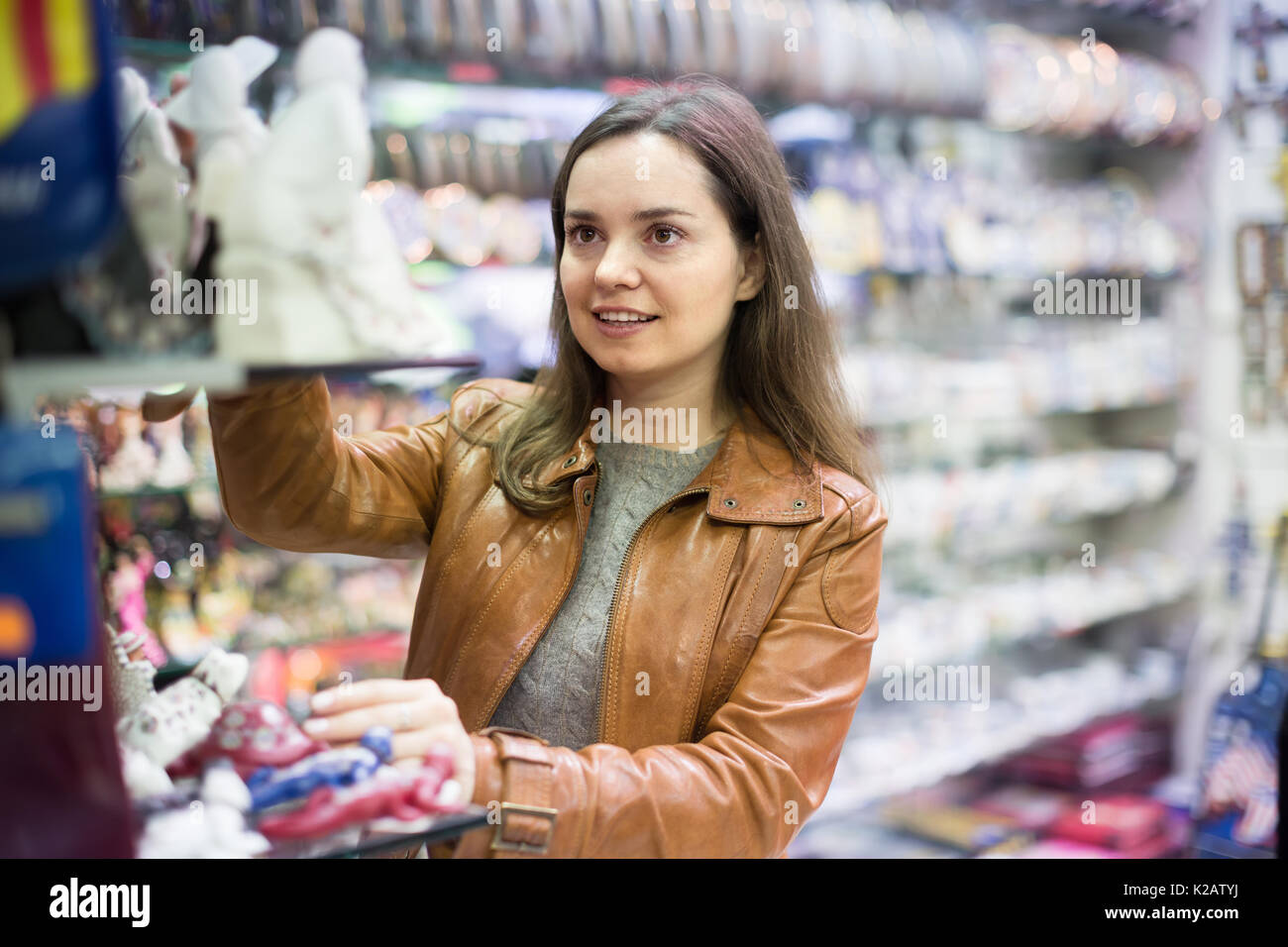 Langhaarige junge Frau kaufen für Speicher im Souvenirshop Stockfoto