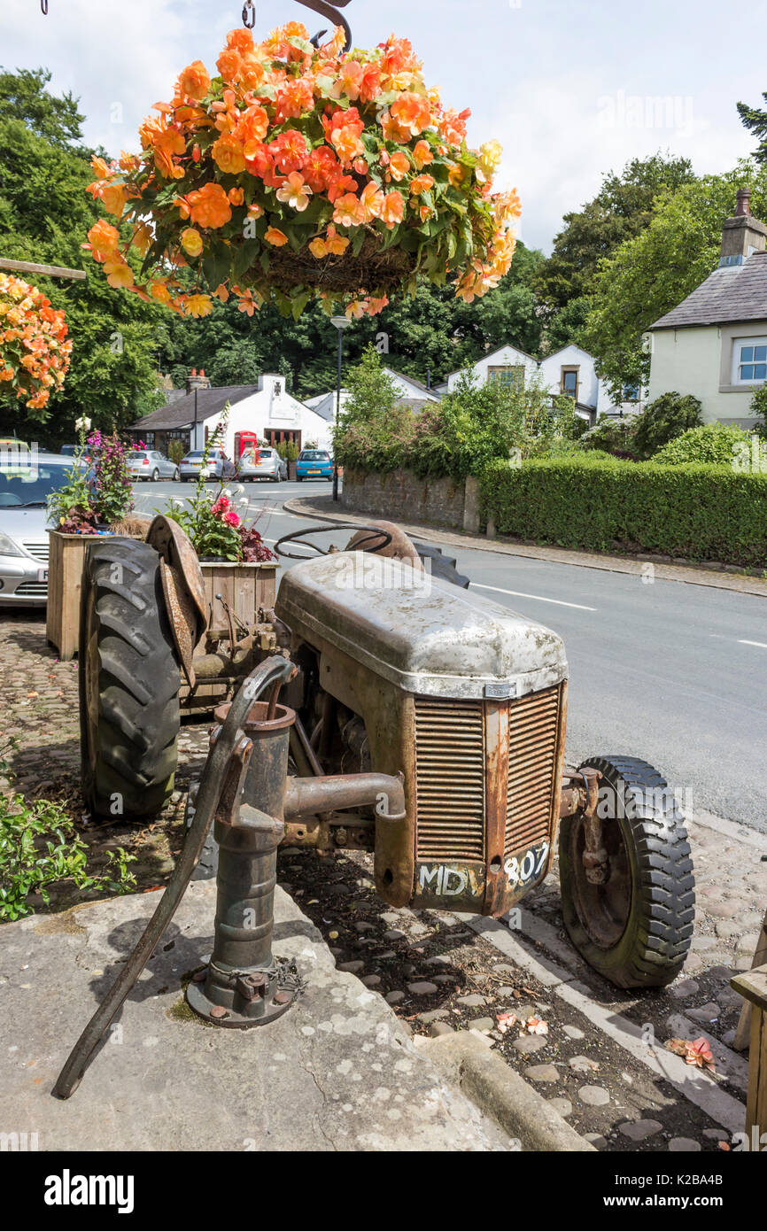 Altmodische Traktor und Handpumpe außerhalb der Scheune, Scorton, Lancashire, England. Stockfoto