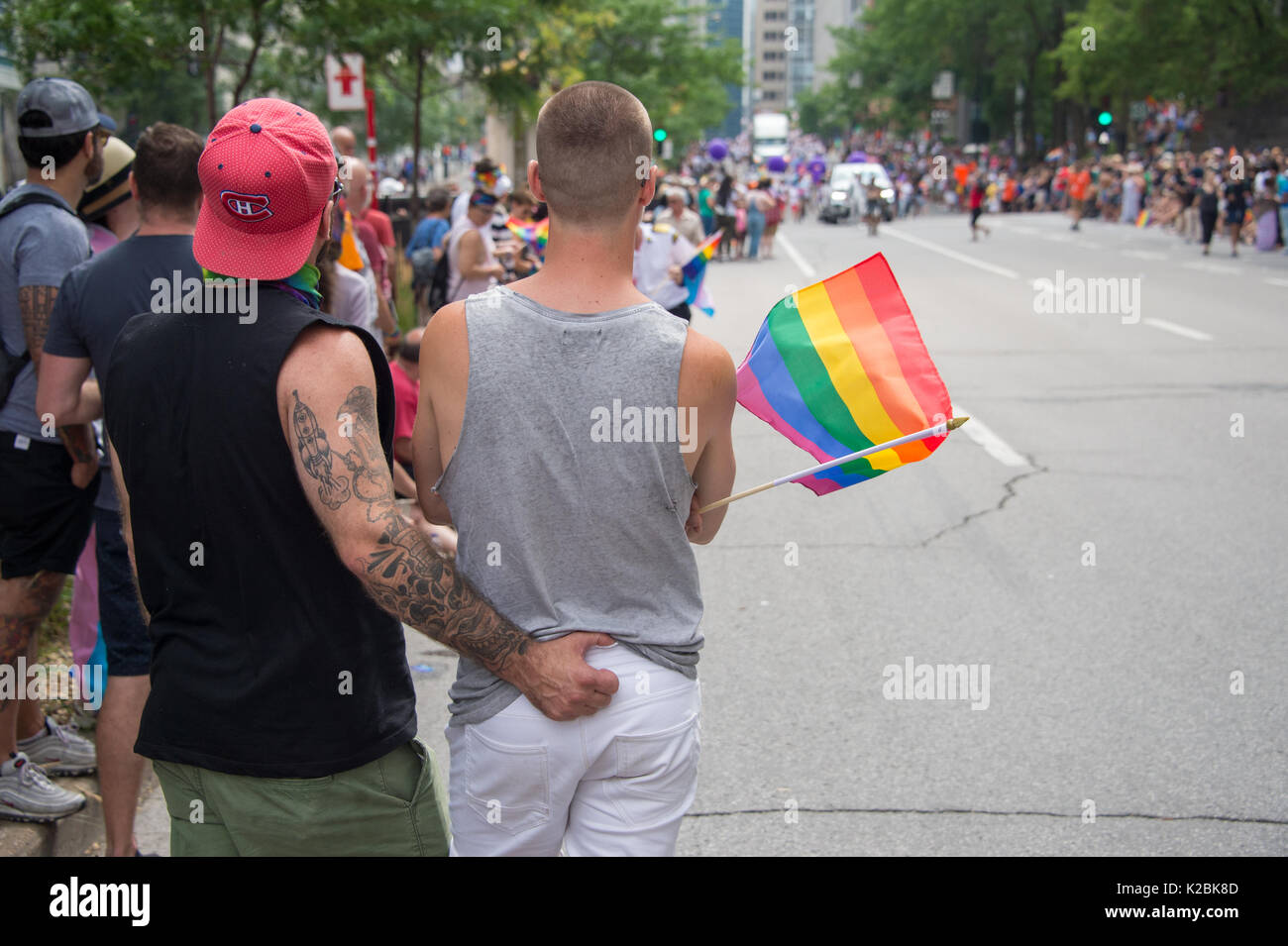 Montreal, Kanada - 20 August 2017: Rückseite des männliche homosexuelle Paar hält ein gay Regenbogen Flagge in Montreal Gay Pride Parade Stockfoto