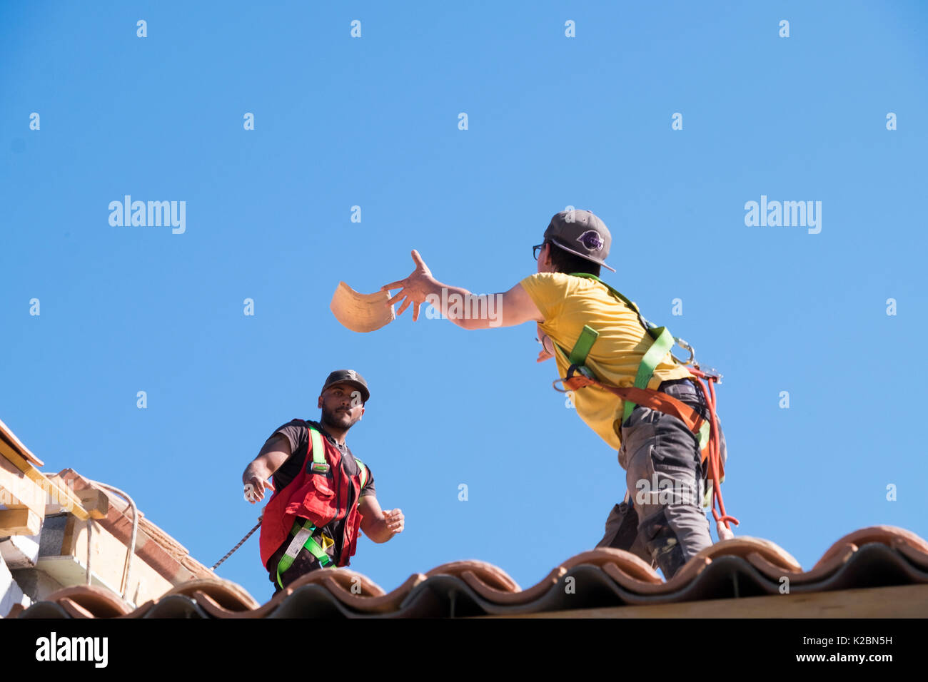 Dachdecker bei der Arbeit der Installation von Fliesen auf einem neuen Haus in der Provence, Frankreich Stockfoto