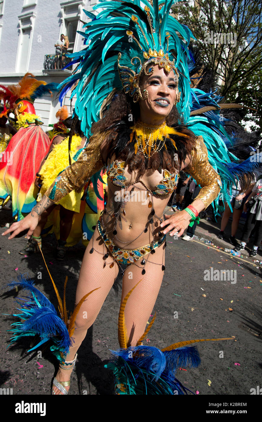 Notting Hill Carnival August 2017. Eine Tänzerin in der Parade tragen ein Gefiederter Kopf Kleid und skimpy Bikini Stockfoto