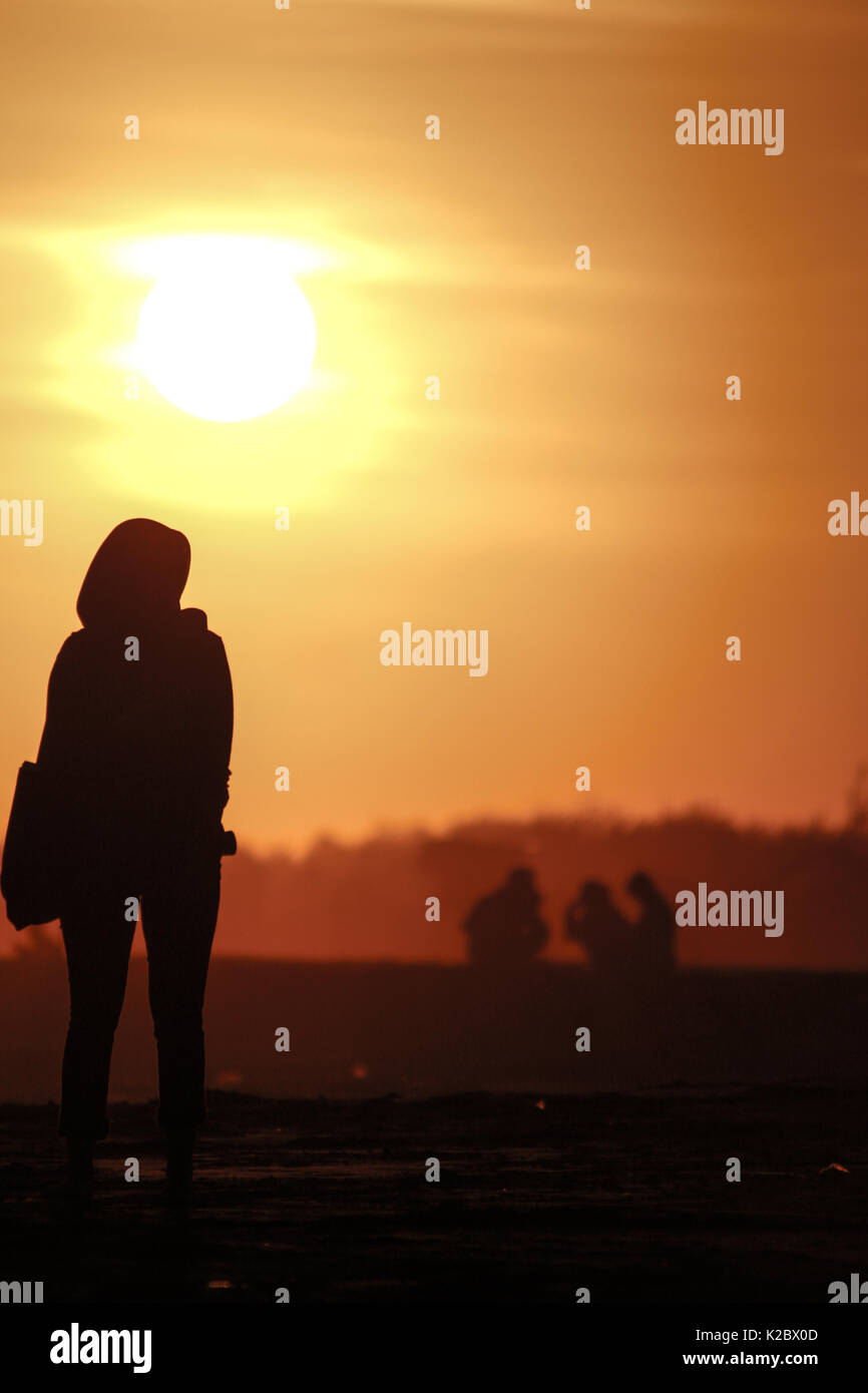 Silhouette einer Frau gegen den Sonnenuntergang Hintergrund in Parangtritis Strand, Spezielle Region Yogyakarta, Indonesien Stockfoto