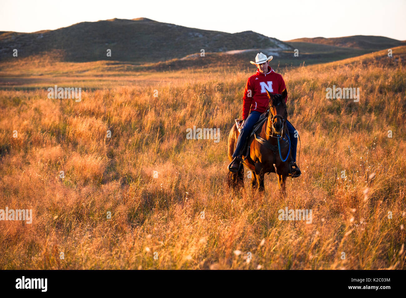 Aaron Preis reiten sein Pferd "Beau" über seine Ranch, Gracie Creek, Sandhills, Nebraska. Garfield County, Nebraska, USA. Oktober 2014. Stockfoto