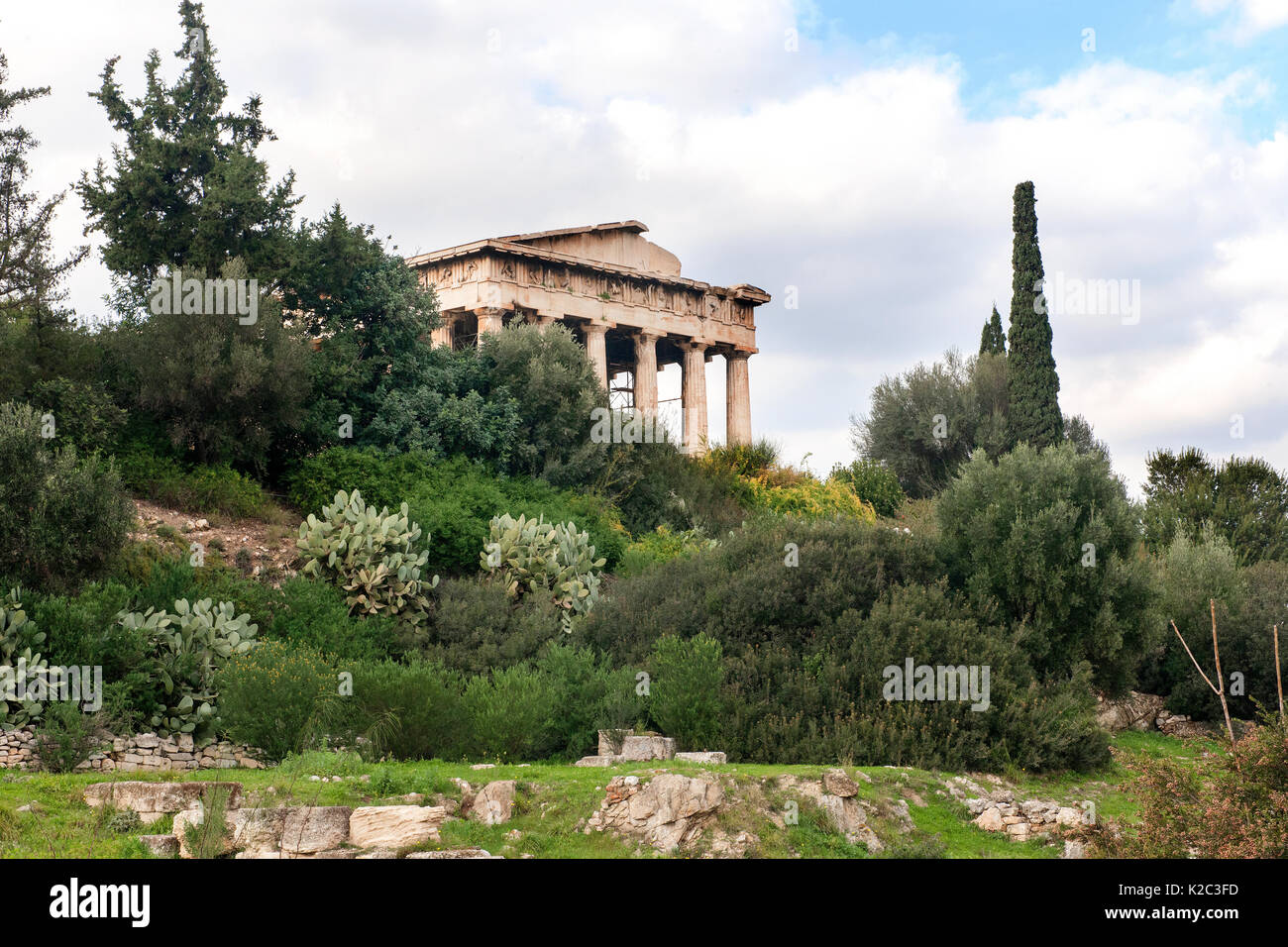Der Tempel des Hephaistos umgeben von Zypressen (Cupressus sempervirens), Ölbäume (Olea europaea) und Feigenkakteen (Opuntia ficus-indica). Region Attika, Athen, Griechenland, im Januar 2011. Stockfoto