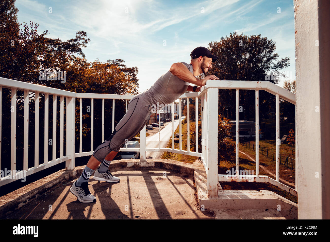 Junge muskulöse Sportler push-up, übung auf der Brücke. Stockfoto