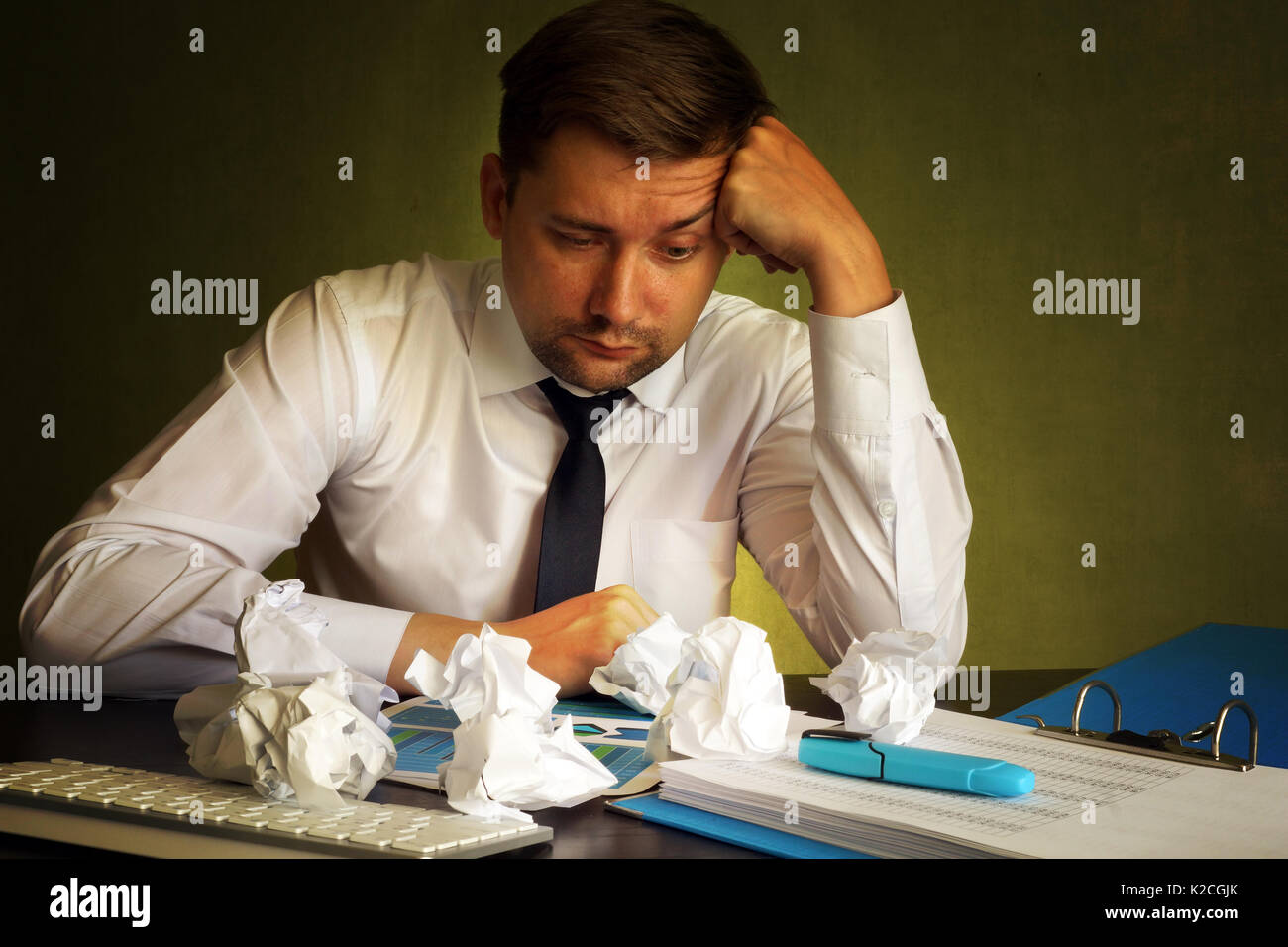 Frustriert Geschäftsmann auf der Suche auf einen Finanzbericht und zerknittertes Papier. Stockfoto