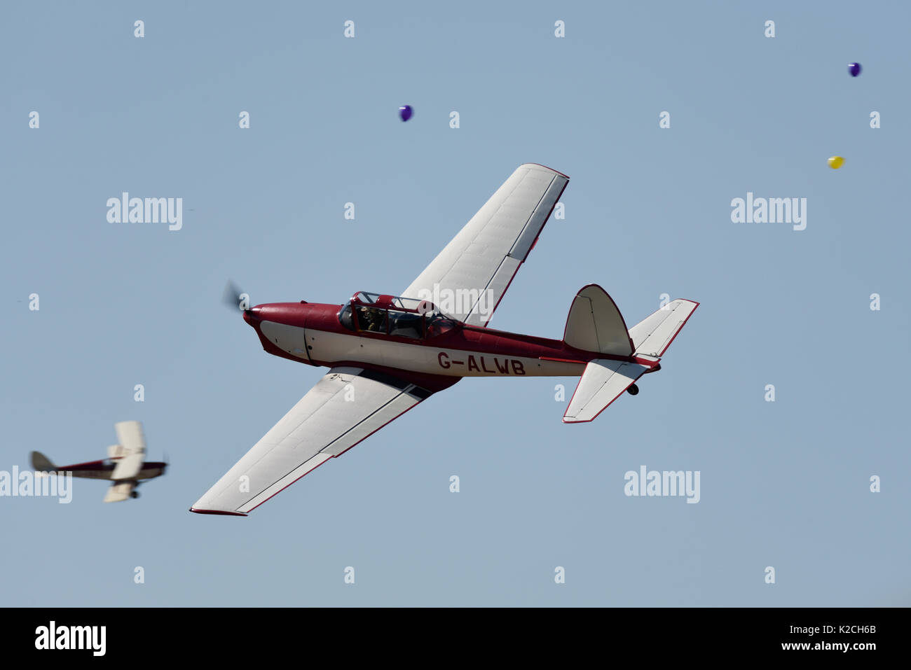 DHC Chipmunk fliegen durch Ballons an der Kleinen Gransden Kinder in Not Airshow. Pilot Dennis Neville. Kapitän Neville's Flying Circus Stockfoto