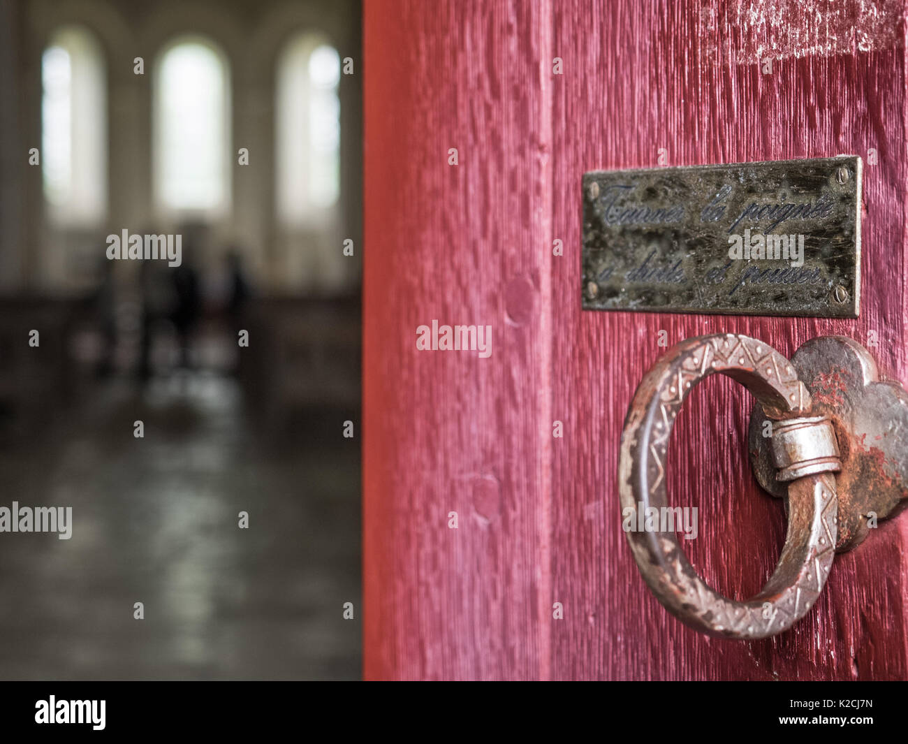 Eine hölzerne Rote Kirche Kapelle Tür schließen Ajar mit Eisen Messing runde ziehen Ring Griff und Plakette beachten Sie Menschen am Altar Stockfoto