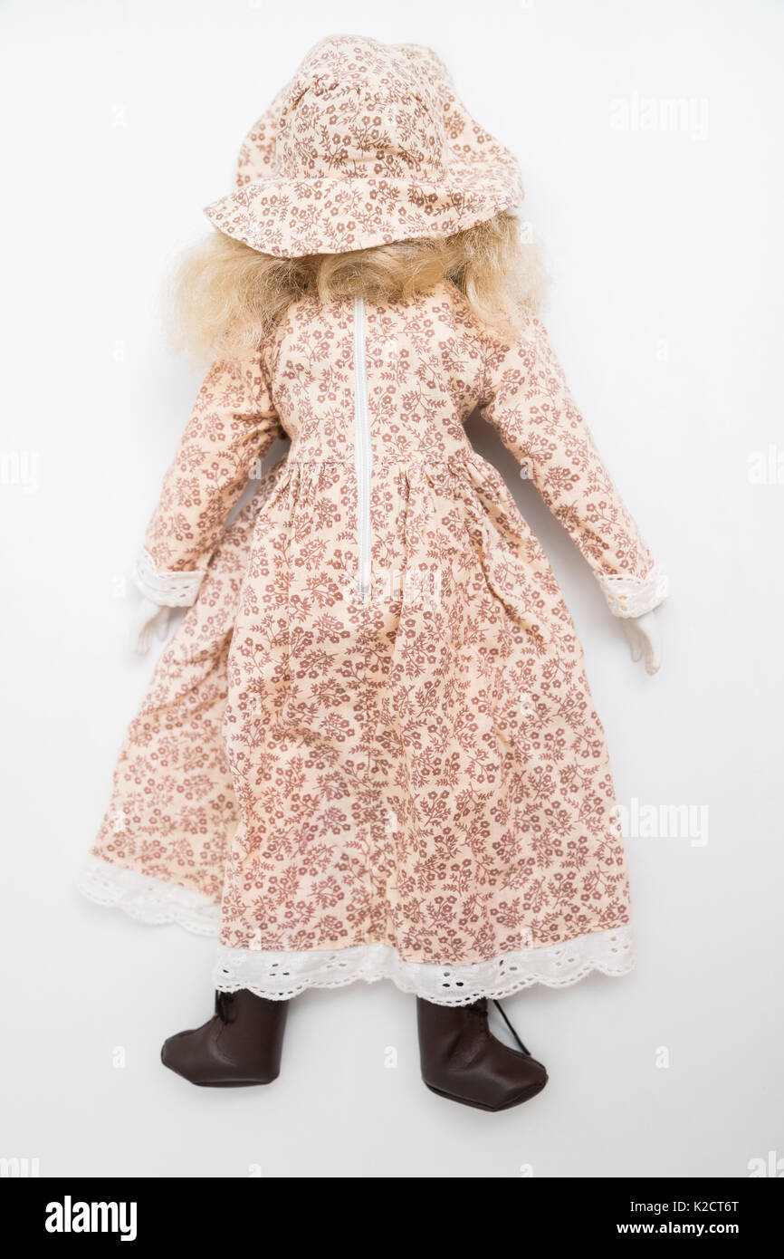 Lag mit dem Gesicht nach unten Keramik Porzellan handmade Vintage Doll withmwavy blonde Haare in Braun alte Bettwäsche textile Kleid mit Stickerei, floraler Druck in Hut und Stockfoto