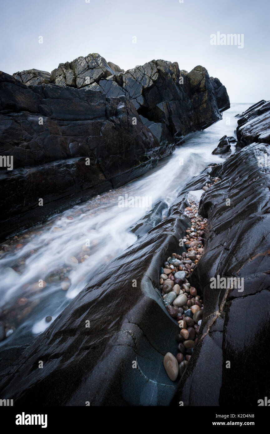 Lange Belichtung von Wasser hetzen durch den Einlass an, Saligo Bay, Islay, Inneren Hebriden, Februar. Stockfoto
