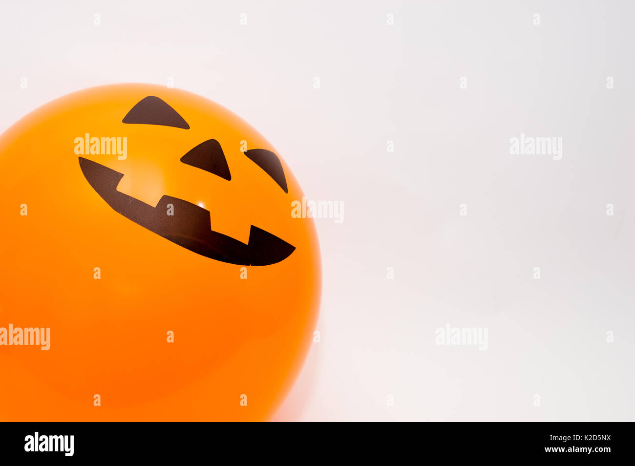 Eine fröhliche Jack-o-Lantern Gesicht auf einem orangefarbenen Ballon, auf weißem Hintergrund Stockfoto