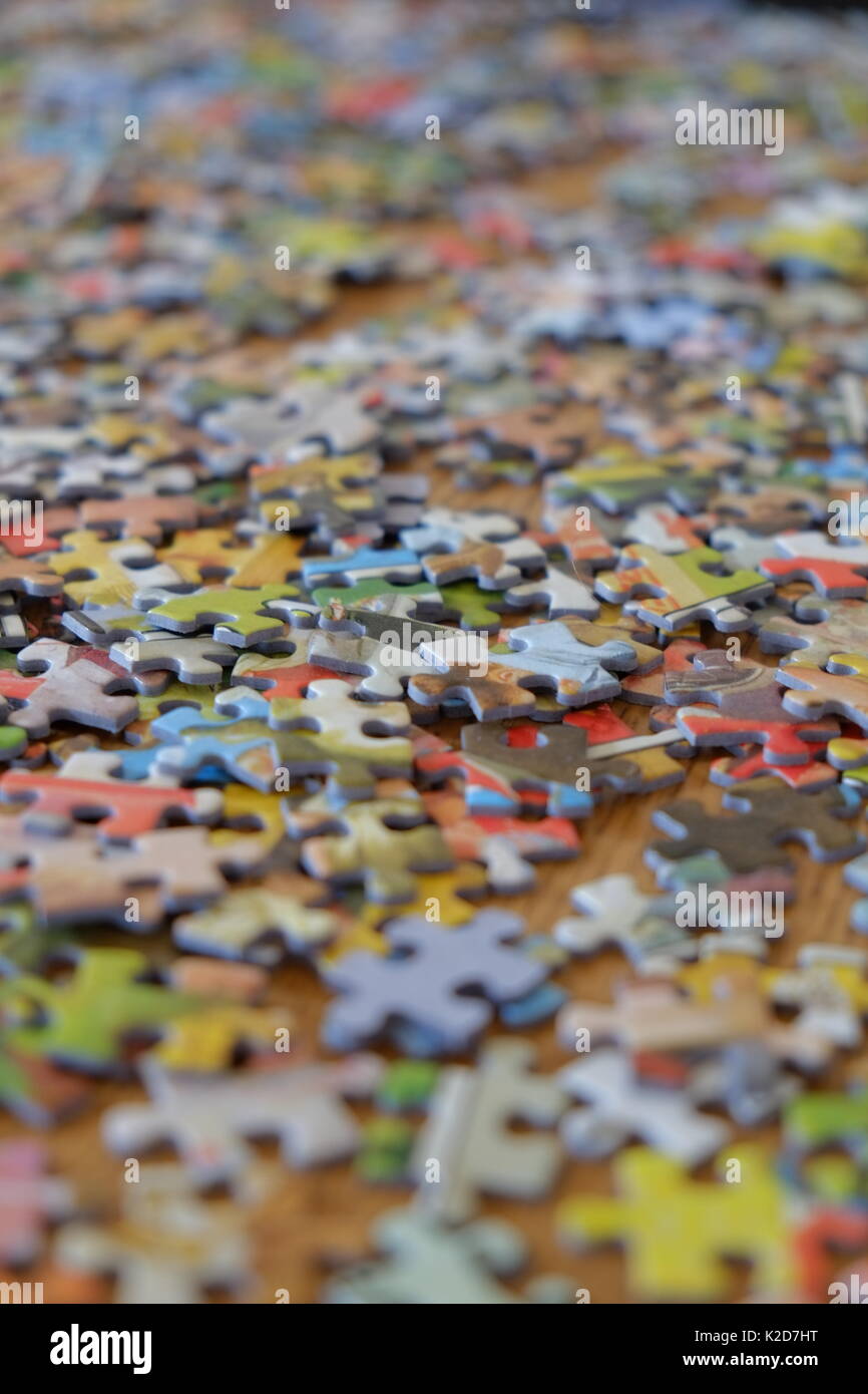 Puzzle Stück zufällig über einen Tisch verstreut Stockfoto