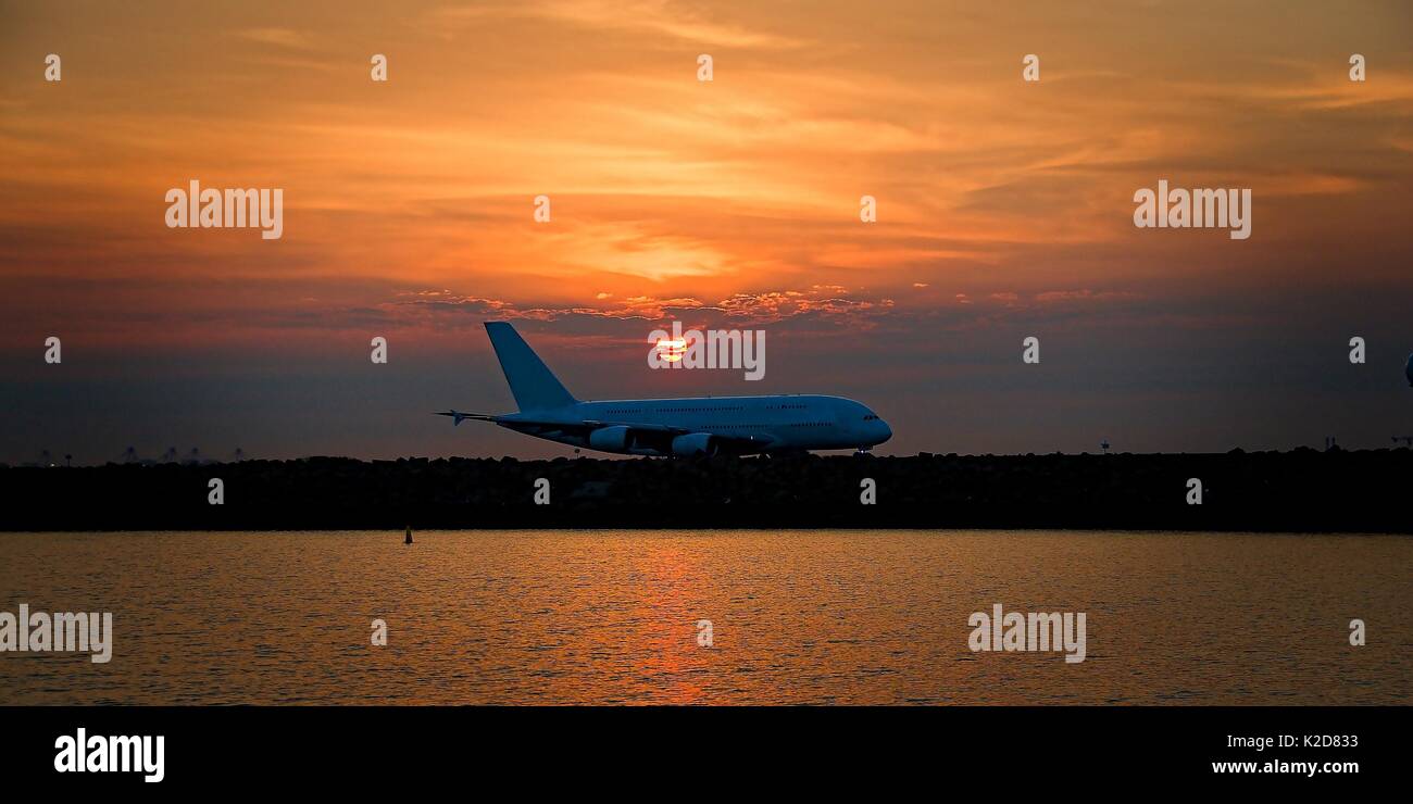 Verkehrsflugzeuge, bei Sonnenuntergang, das Rollen in auf der Rollbahn am Sir Kingsford Smith Flughafen, Maskottchen, Sydney, Australien. Stockfoto