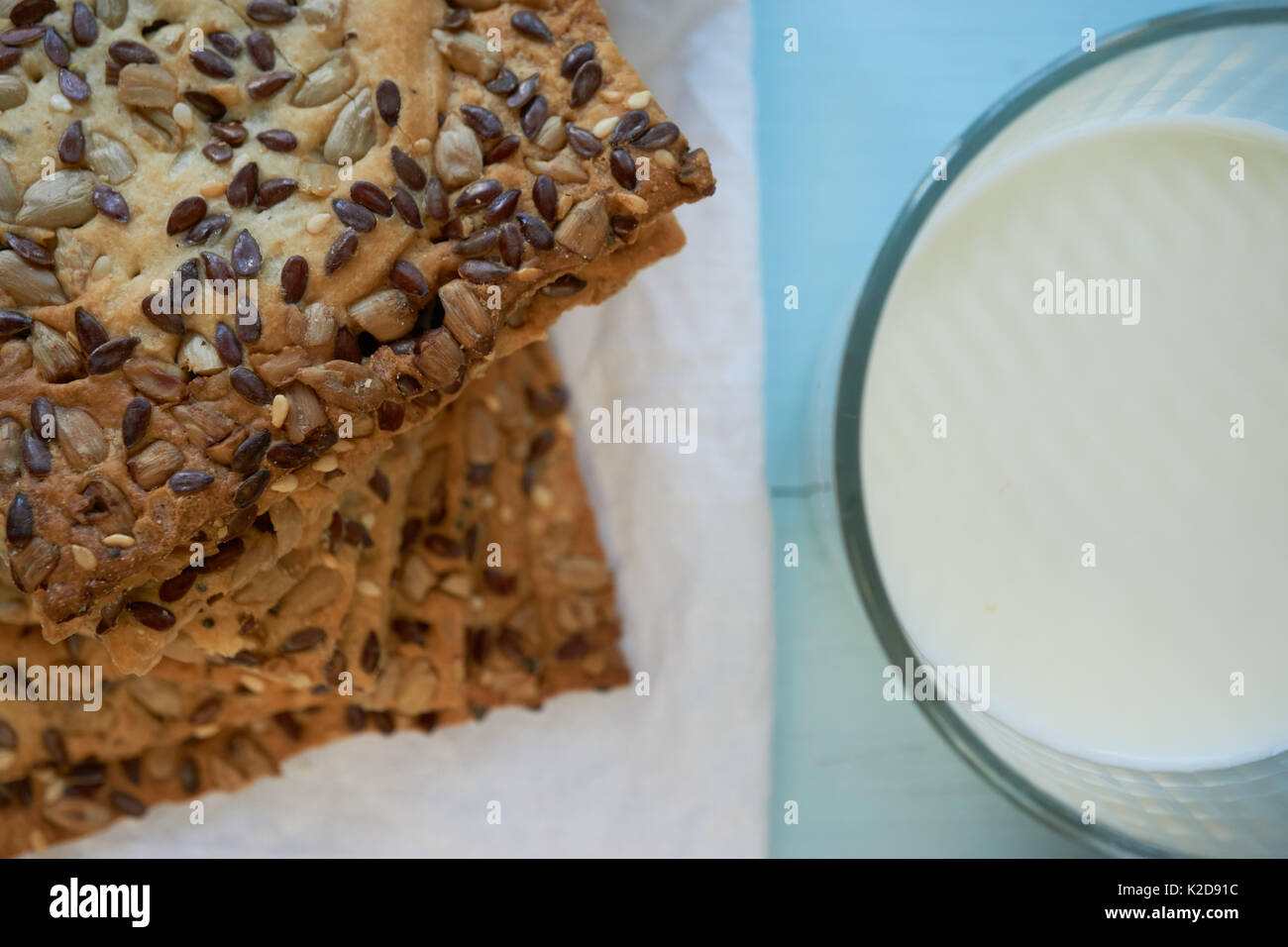 Nahaufnahme der frische Cookies bedeckt mit verschiedenen Samen Chia, Sesam, Sonnenblumen mit Glas Milch Stockfoto