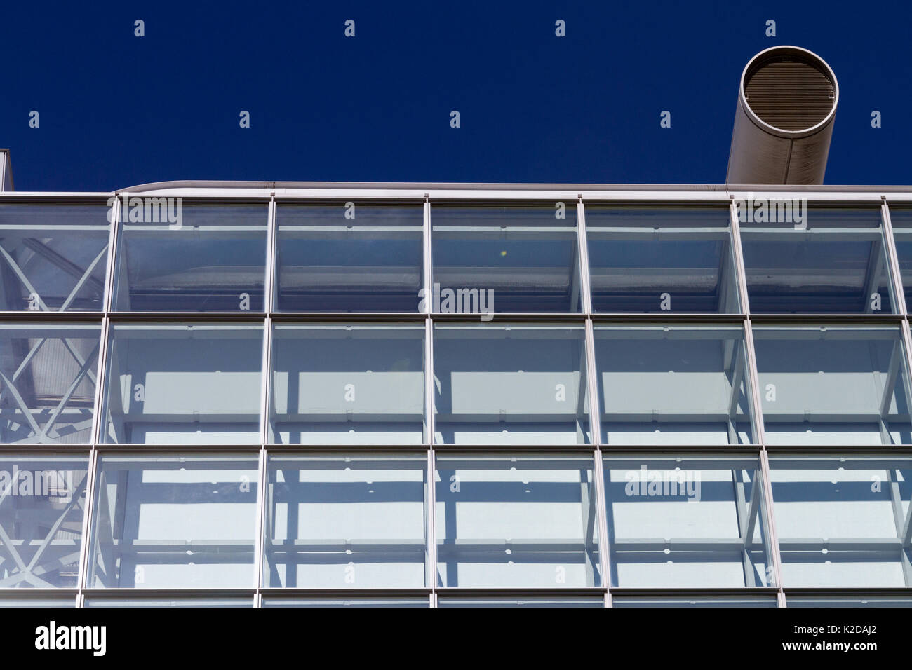 Detail eines modernen Glasgebäudes mit einem großen Schlot auf dem Dach. Tokio, Japan. Stockfoto