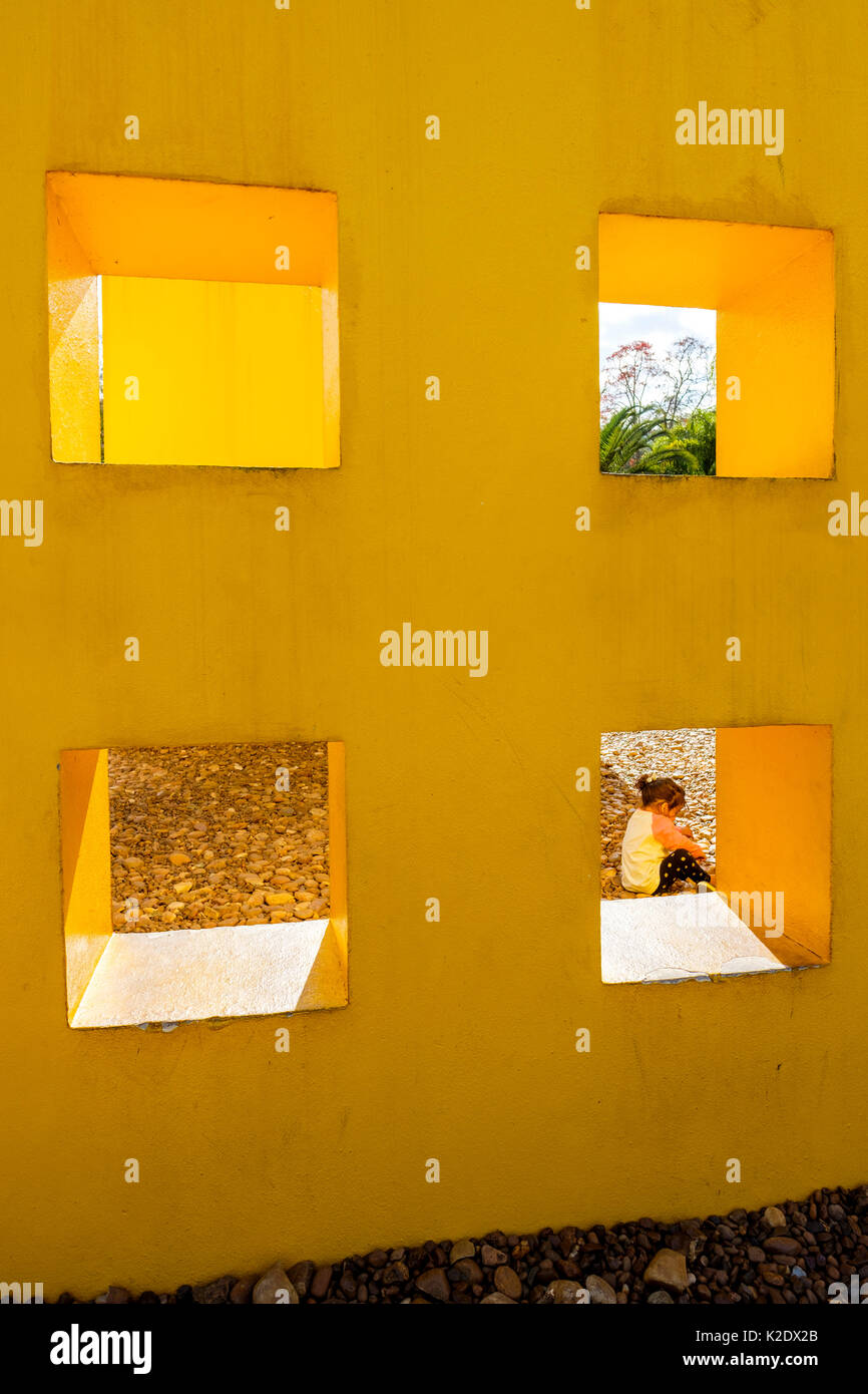 Junges Mädchen spielt auf dem Boden auf dem Penetrável Magic Square # 5 Kunstinstallation von Helio Oiticica, Inhotim Institute, Brumadinho, Minas Gerais, Brasilien. Stockfoto