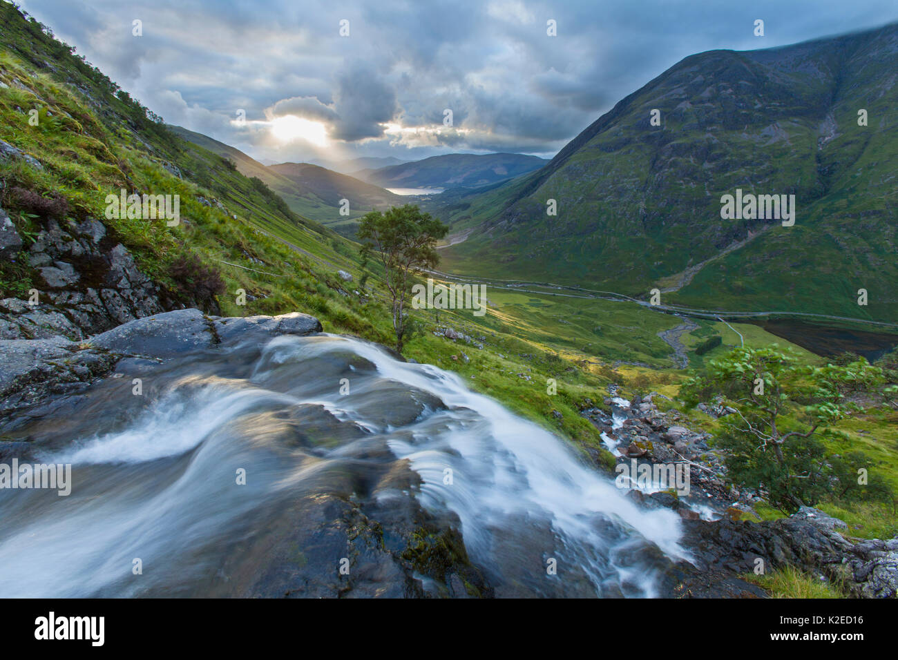 Wasserfall über Loch Achtriochtan mit Aonach Eagach im Hintergrund, Glen Coe, Highlands, Schottland, UK, August 2013. Stockfoto