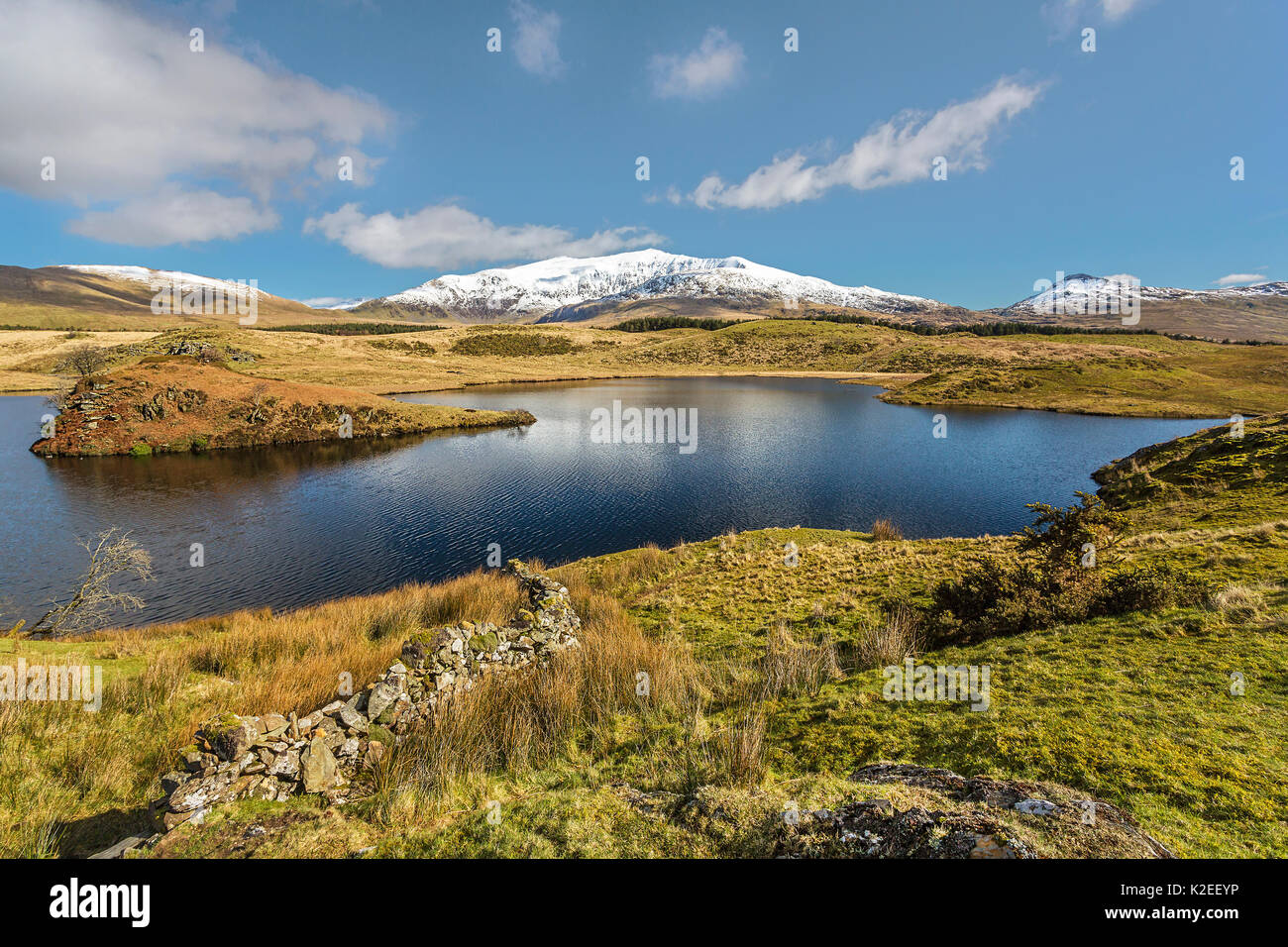 Mount Snowdon (Yr Wyddfa) von Westen gesehen über Llyn Dywarchen direkt an der B4418 Road, Snowdonia, North Wales, UK, März. Stockfoto