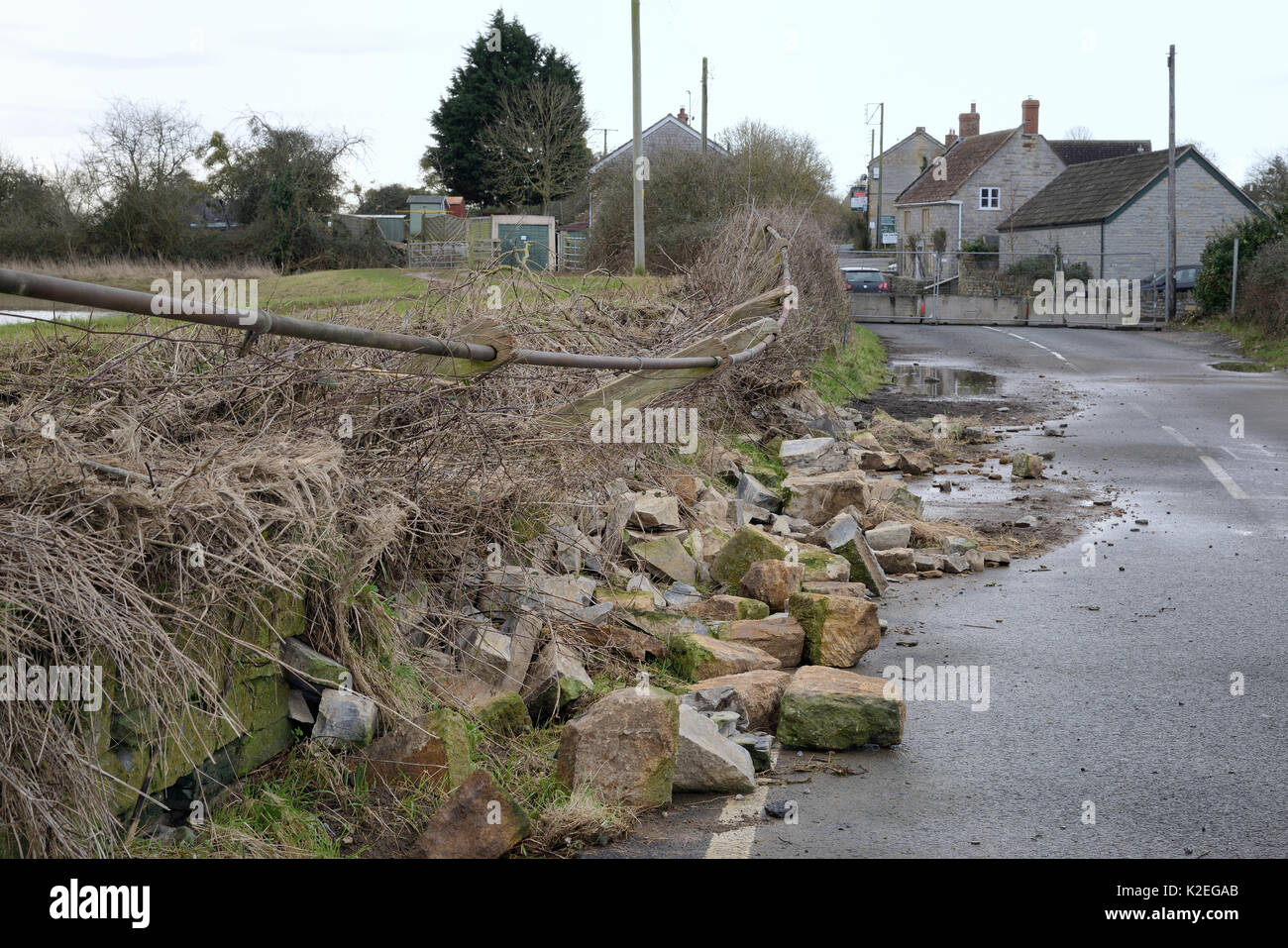 Straßensperrung und eingestürzte Mauer aus Stein, die durch die schweren Überschwemmungen verursacht nach Wochen der Heavy Rain, lange Lode, Somerset, Großbritannien, Februar 2014. Stockfoto