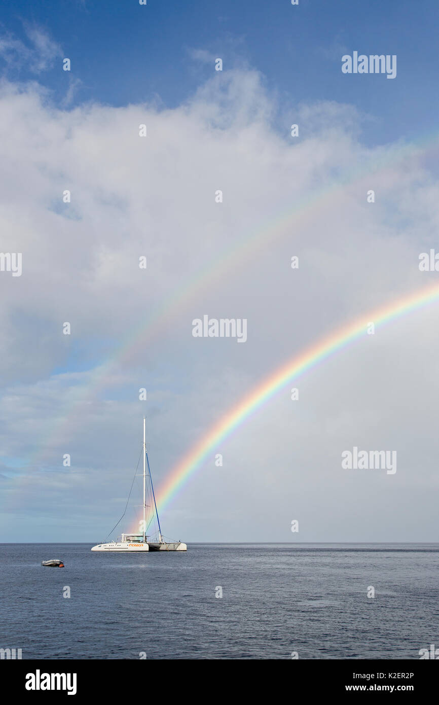 Segelboot und Regenbogen in der Nähe der Küste von Dominica, Karibik, Atlantik. Stockfoto