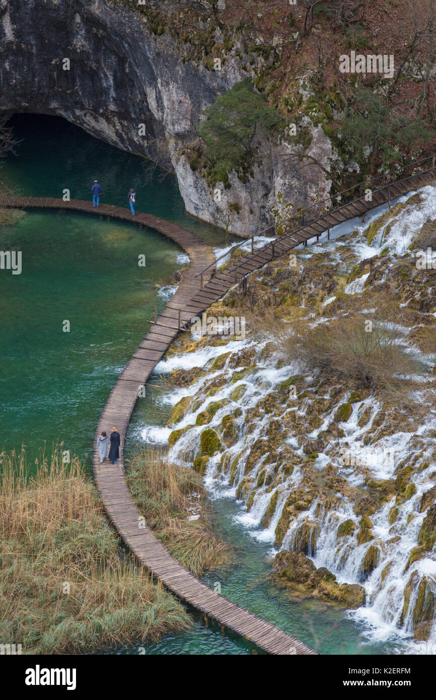 Touristen zu Fuß auf der Promenade unter Velike Kaskade Wasserfälle, Nationalpark Plitvicer Seen, Kroatien. Januar 2015. Stockfoto