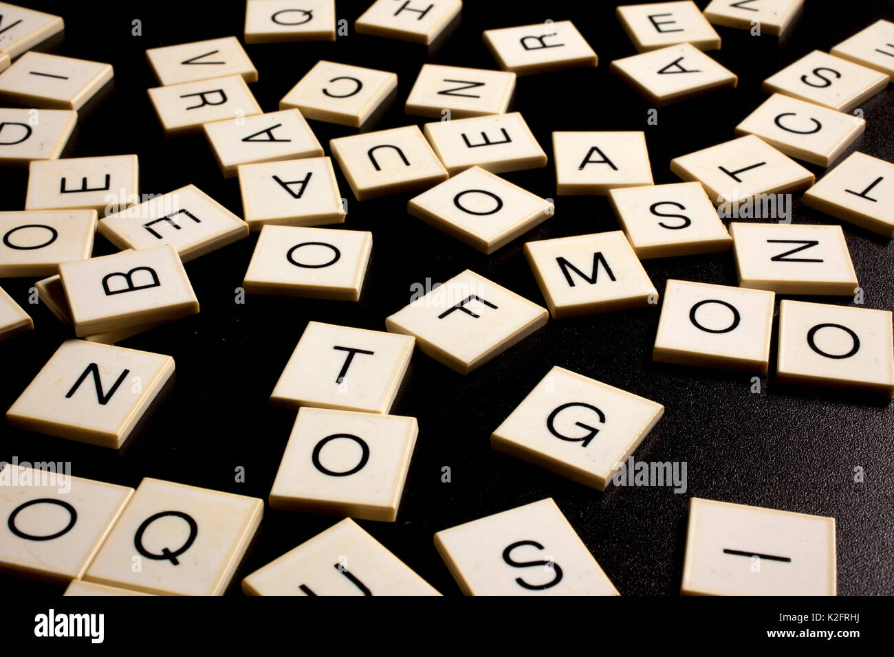 Zufällige Buchstaben auf schwarzem Hintergrund - Legasthenie Stockfoto