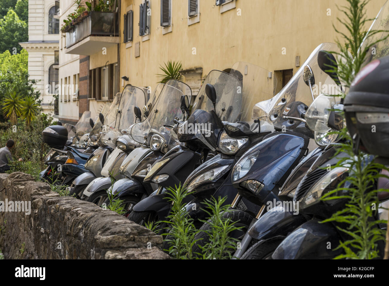 Verschiedene Motorroller sind in alten gemütlichen Straße geparkt in Rom, Italien. Architektur und Sehenswürdigkeiten von Rom. Postkarte von Rom Stockfoto