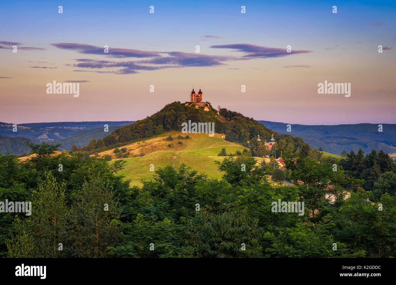 Obere Kirche mit zwei Türmen und barocken Kalvarienberg in Banska Stiavnica, Slovaka bei Sonnenuntergang. Banska Stiavnica ist eine vollständig erhaltene mittelalterliche Stadt und Stockfoto