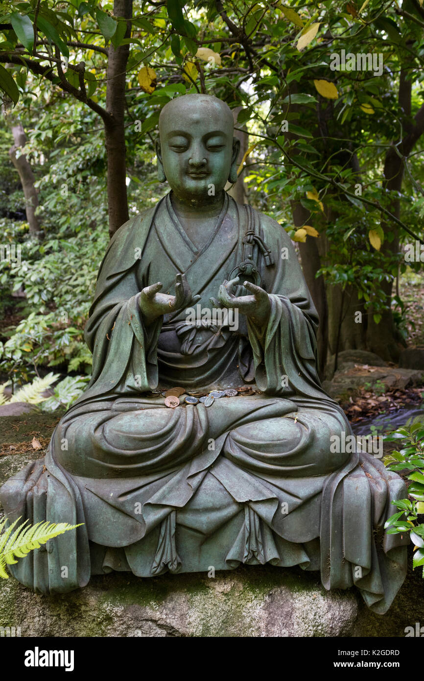 Tokio, Japan - Buddha Statue mit Japanische Münzen im Garten der Nezu Museum Stockfoto