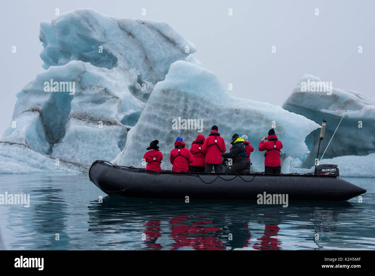 Norwegen, Svalbard, Spitzbergen. Nordvest-Spitsbergen Nationalpark, liefdefjorden. Abenteuer Touristen erkunden großer Eisberg durch Zodiac. Stockfoto
