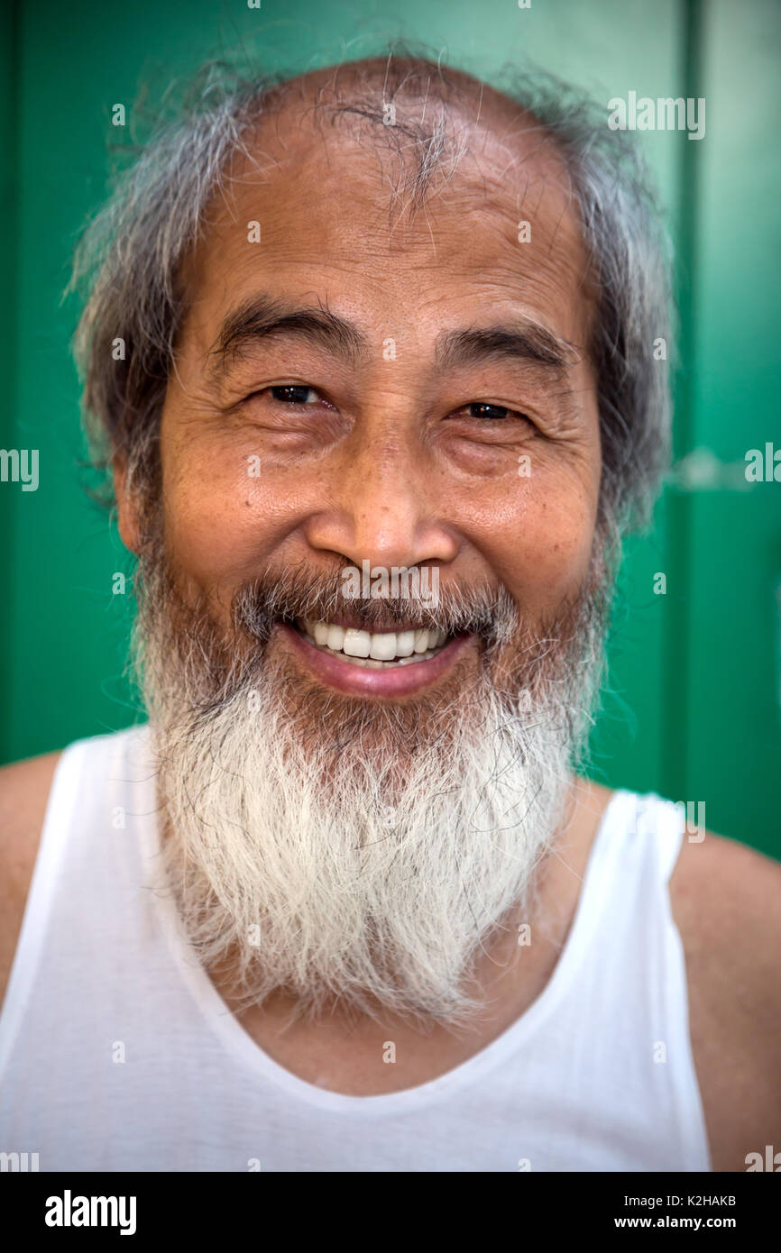 Portrait von älteren Mann smlie lächelnd in Hong Kong China mit Bart Stockfoto