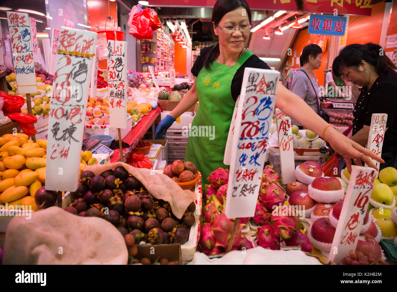 Frau Verkauf von Obst in Hongkong auf dem Markt Stockfoto