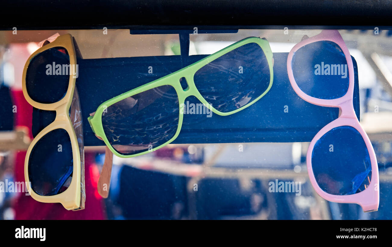 Bunte Sonnenbrille von rosa, gelb und grün Farben hängen an Bunte Sonnenbrille von rosa, gelb und grün Farben hängen an