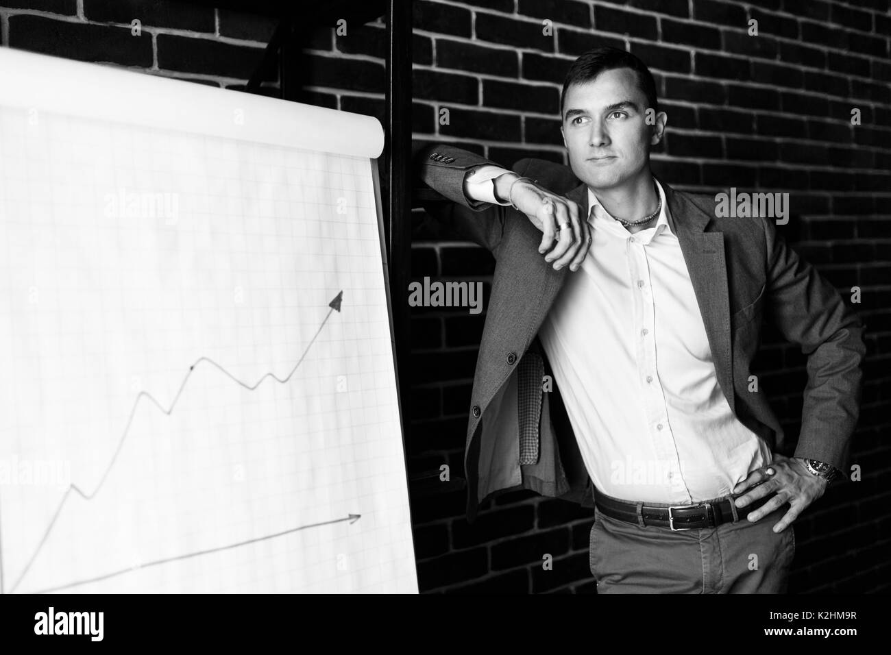 Schwarz Weiss Foto Von Business Mann Neben Plakat Mit Grafik Auf Mauer Hintergrund Stockfotografie Alamy