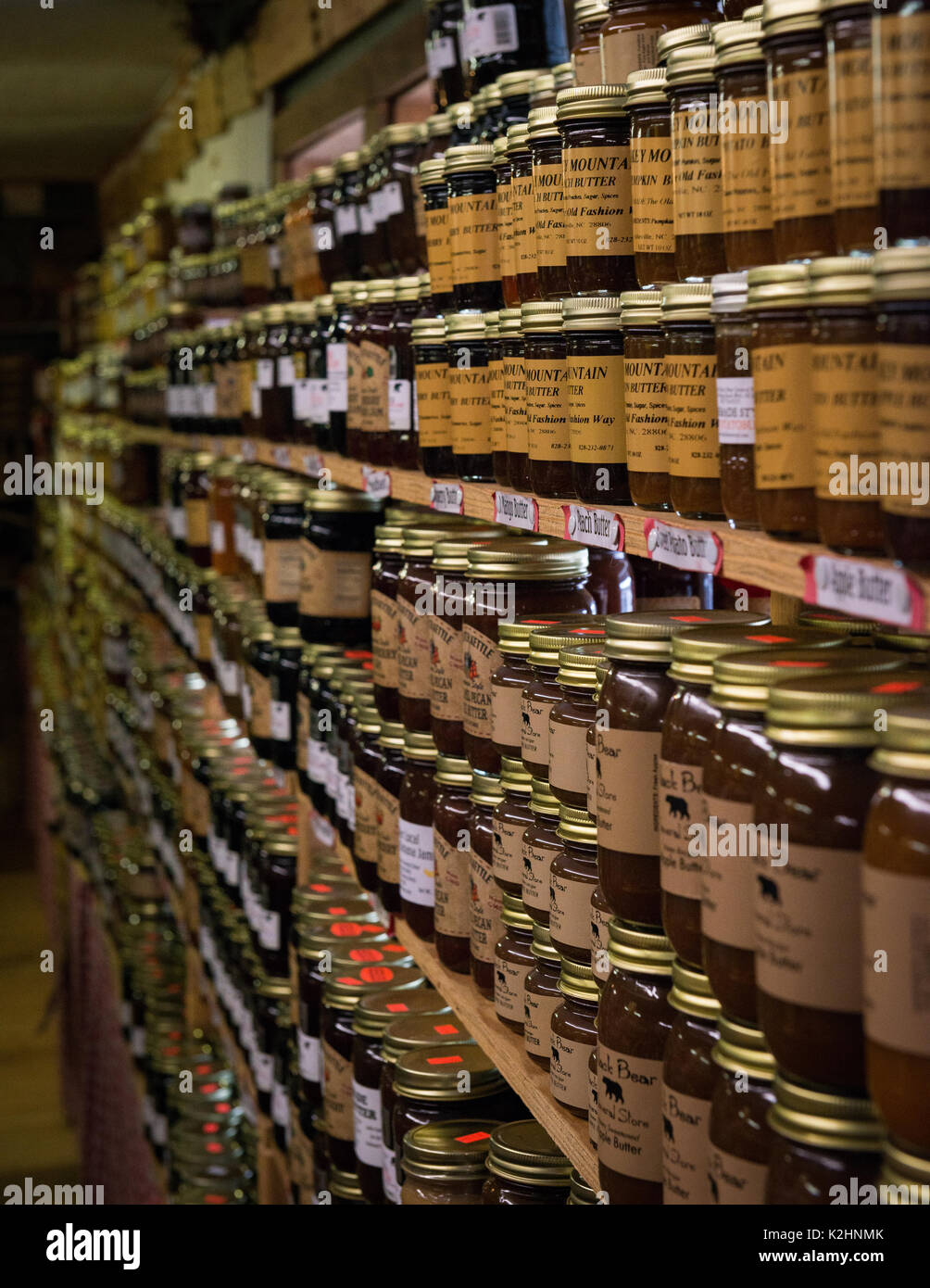 Reihen von Apple Butter und Marmelade auf Old Country Store Shelves - Canning Essen Lagerungsart Metall Canning Deckel auf Gläsern sind gekocht bis abgedichtet Stockfoto