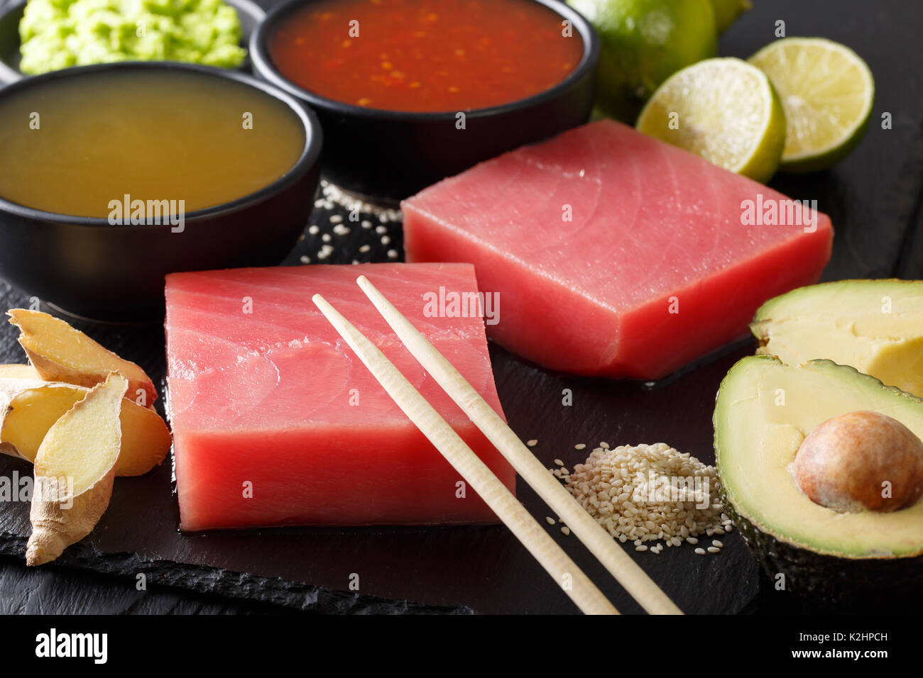 Rohen Thunfisch mit asiatischen Saucen, Avocado, Kalk und Sesam close-up auf dem Tisch. Horizontale Stockfoto