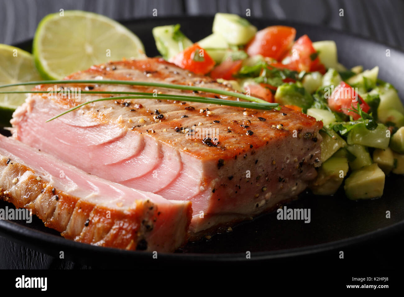 Cilantro-Lime gegrillter Thunfisch mit Avocado Salatgurke Salsa closeup auf einem Teller. Horizontale Stockfoto