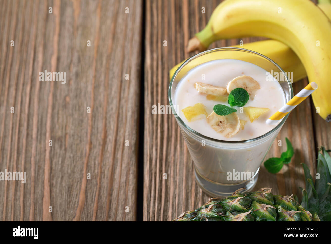 Glas Joghurt mit Banane und Ananas. Platz für Text Stockfoto