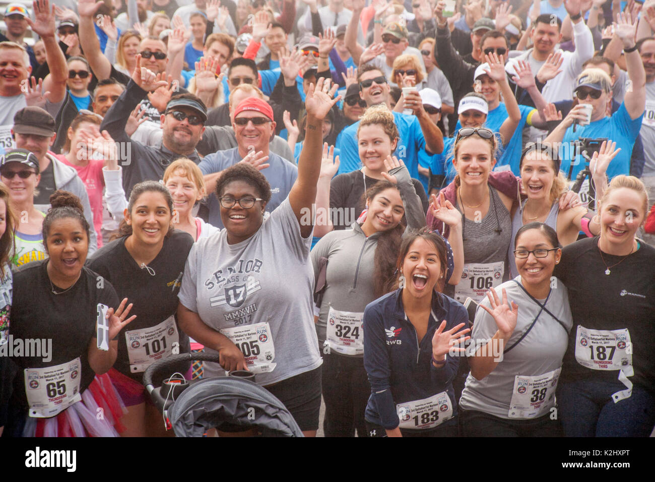 Multirassischen militärische Frauen bestätigen eine Hommage von Zuschauer und Teilnehmer vor konkurrieren in einem Wettlauf im Huntington Beach, CA. Stockfoto