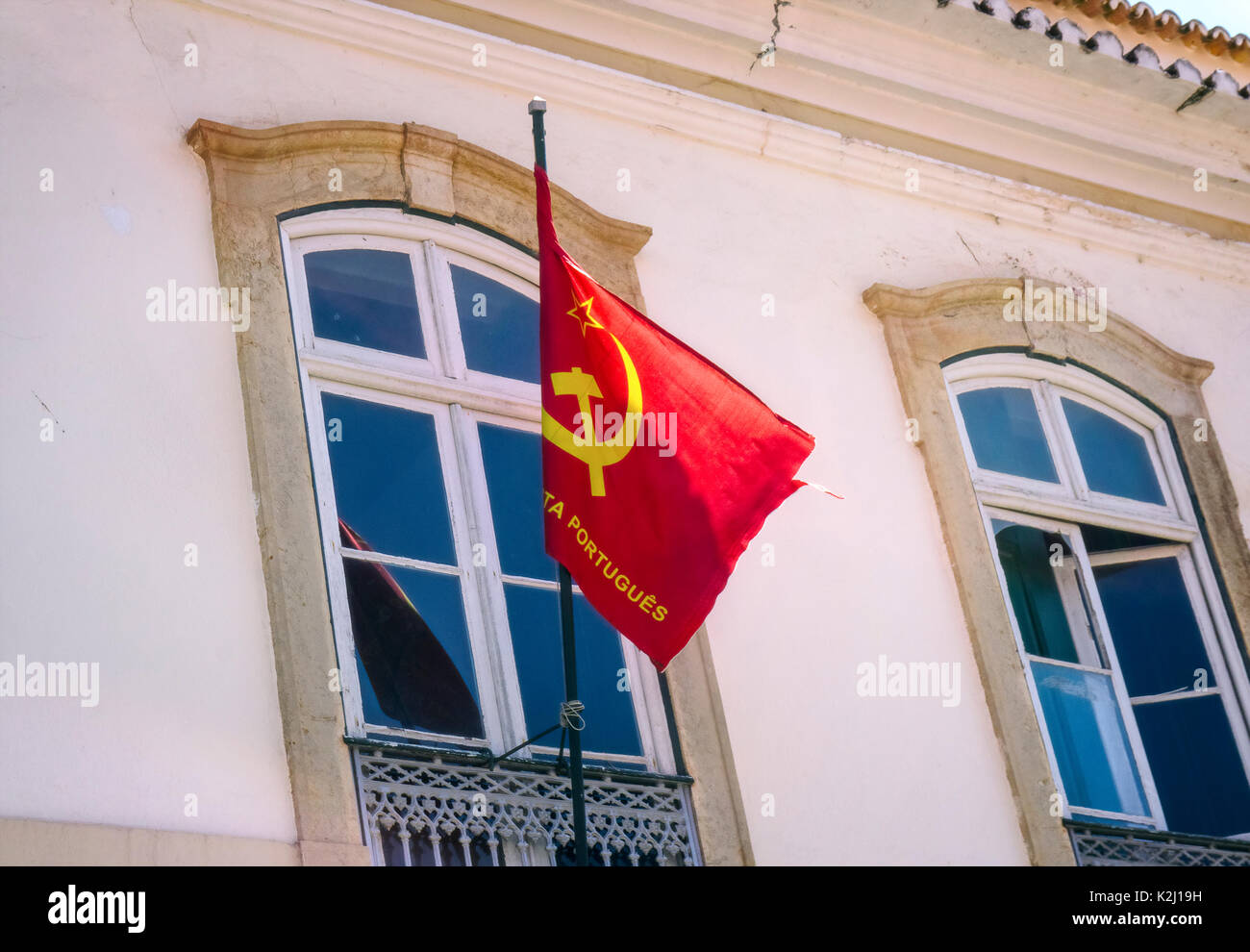 Flagge der portugiesischen Kommunistischen Partei (Partido Comunista Português) auf einem Gebäude in Faro, Portugal. Stockfoto
