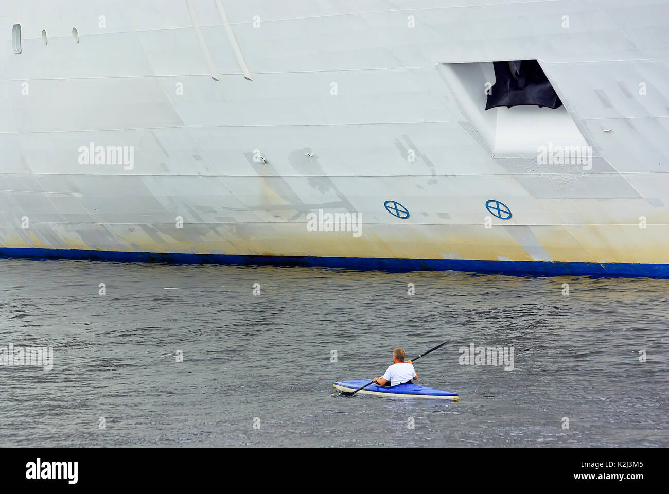 Kleinen Paddelboot überholt riesigen Ozeandampfer. Stockfoto