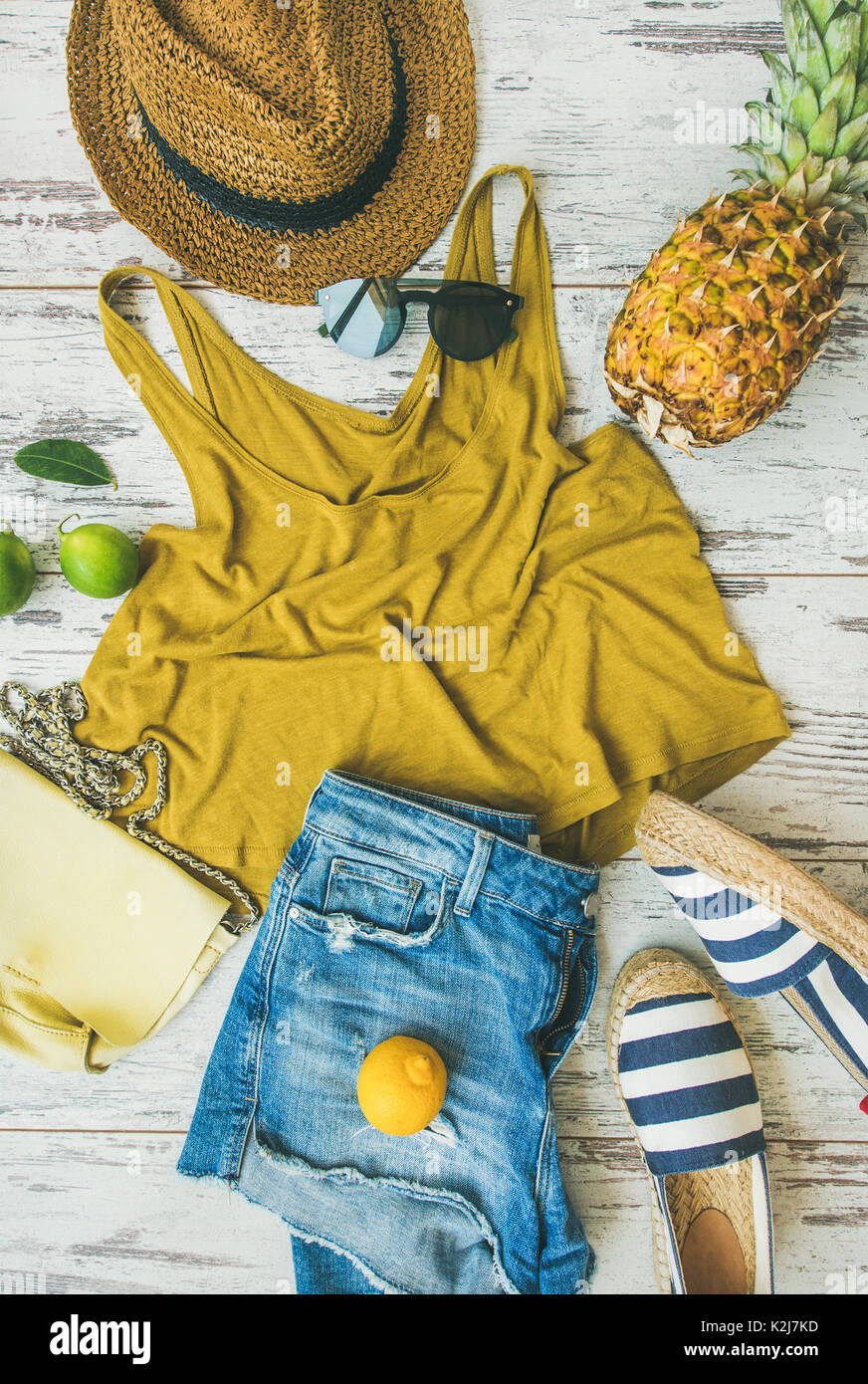 Farbenfrohe Sommer Mode outfit Flachbild-legen. Denim Shorts, Stroh Sonnenhut, Gelb oben, espadrillas, Gelb Leder Tasche, Sonnenbrille, Ananas-, Limonen-, Limetten- und Le Stockfoto