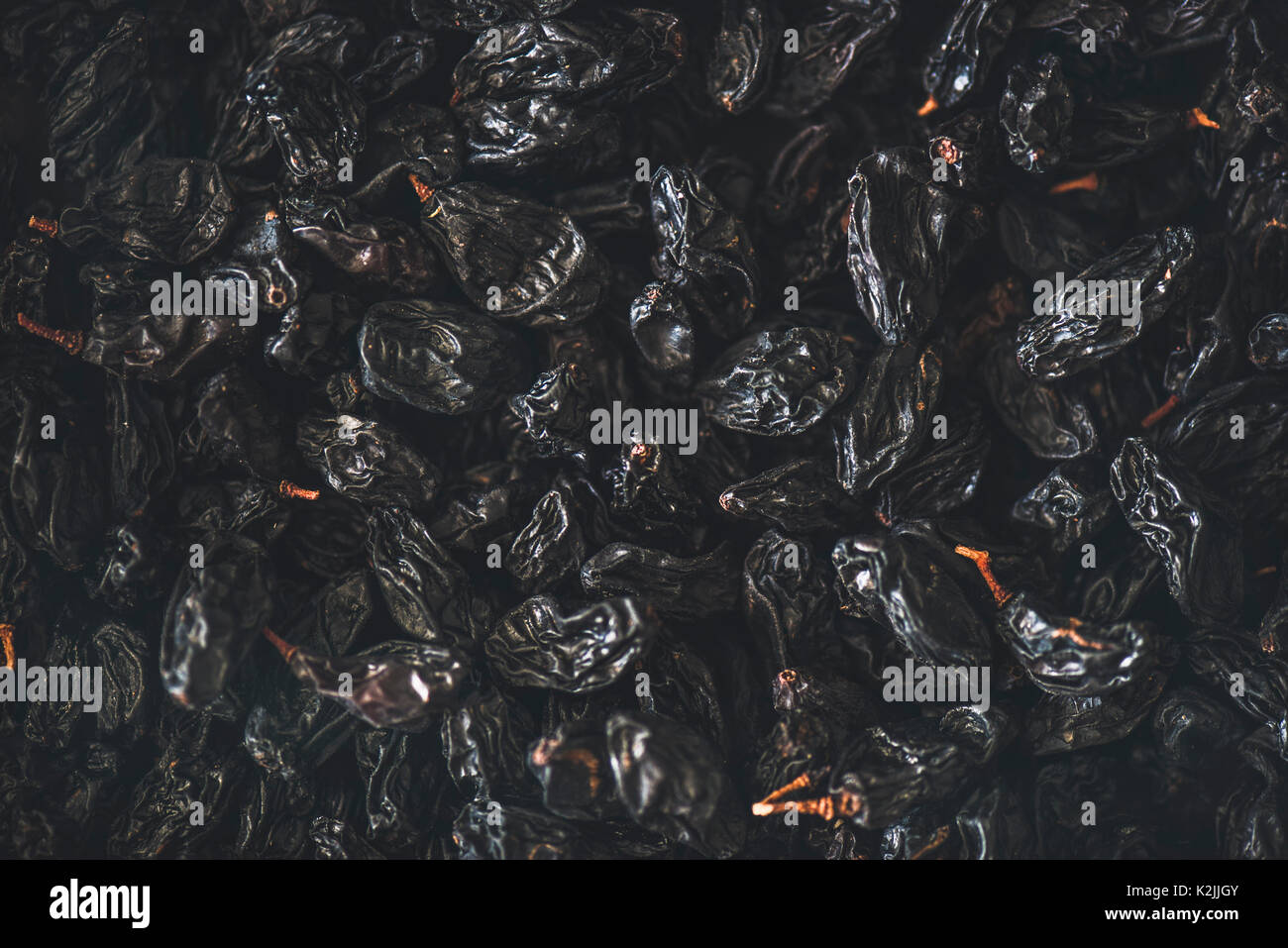 Flachbild-lay von Schwarz getrocknete Rosinen, Ansicht von oben, close-up. Textur und Hintergrund Stockfoto