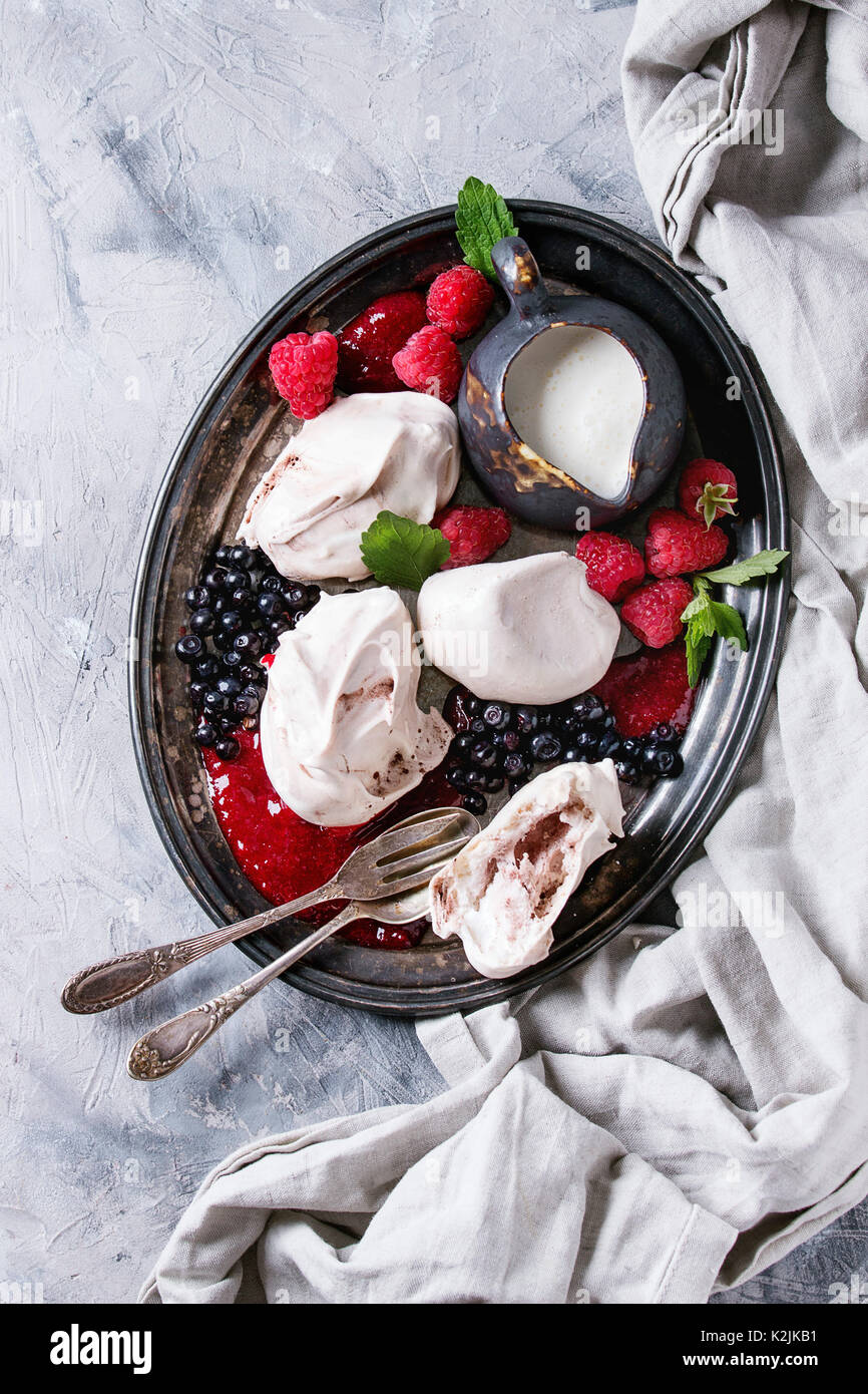 Traditionelle Sommer dessert Eton Mess. Baiser, Kanne, Creme, Beeren Marmelade, frischen Heidelbeeren, Himbeeren auf vintage Fach, mit Minze dekoriert ov Stockfoto