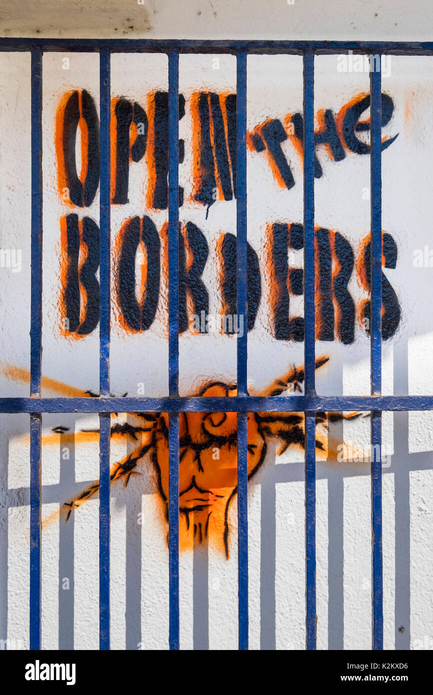 Graffiti deklarieren Öffnen der Grenzen und die geballte Faust holding Stacheldraht hinter Gittern Baskenland Spanien Stockfoto