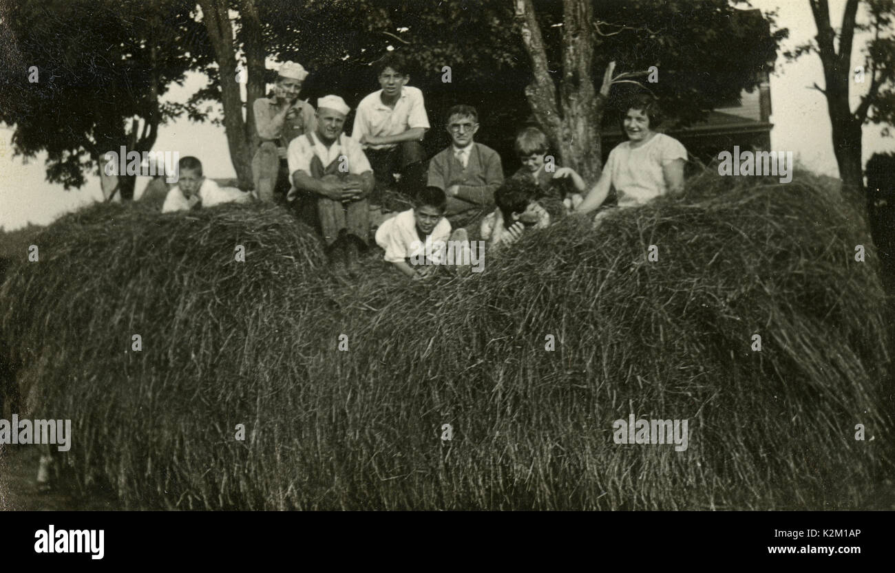 Antike c 1930 Foto, Familie und Freunde spielen in einem großen Haufen von Heu. Quelle: original Foto. Stockfoto