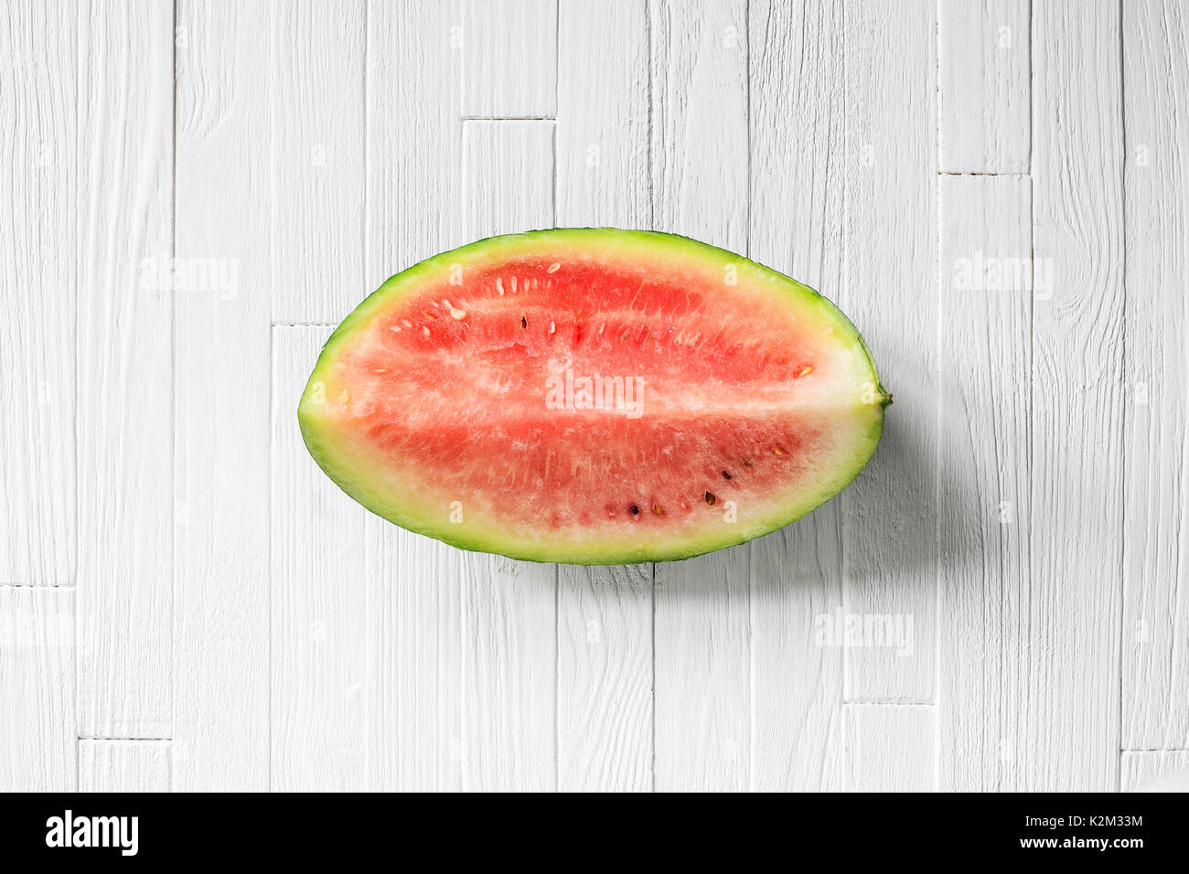 Ein Viertel einer Wassermelone auf weißem Holz Hintergrund der Ansicht von oben. Stück frische Wassermelone auf weißen Tisch Stockfoto